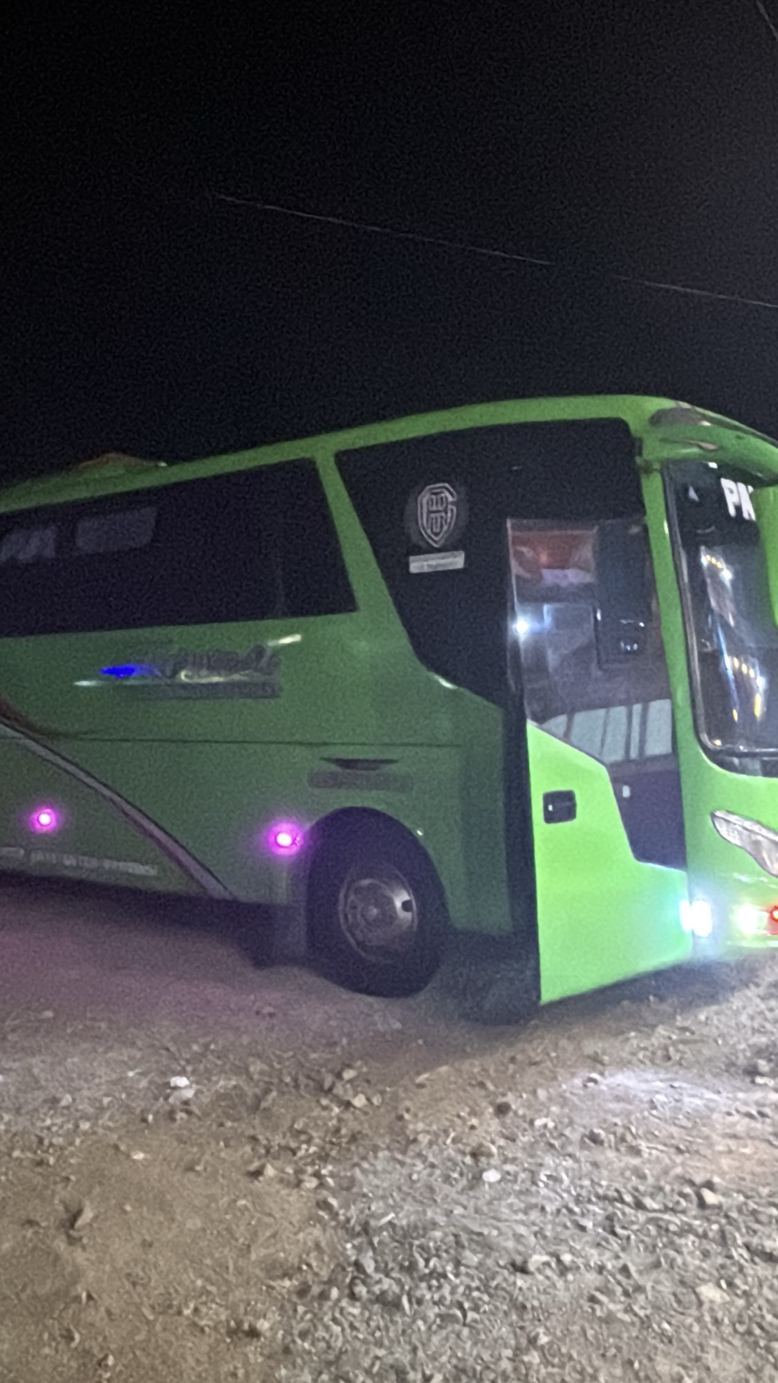 The bus parked at a rest stop in the middle of the night