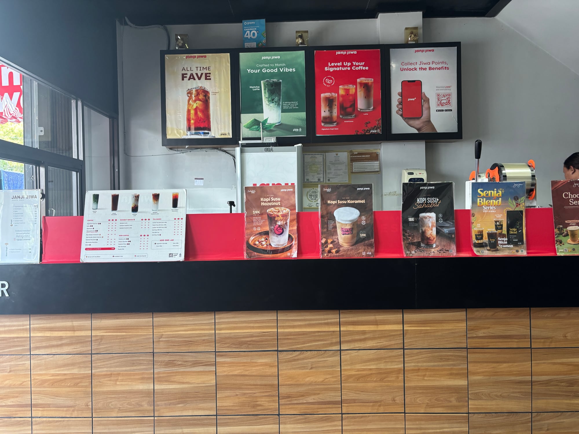 A coffee shop's menu boards displaying various coffee drinks