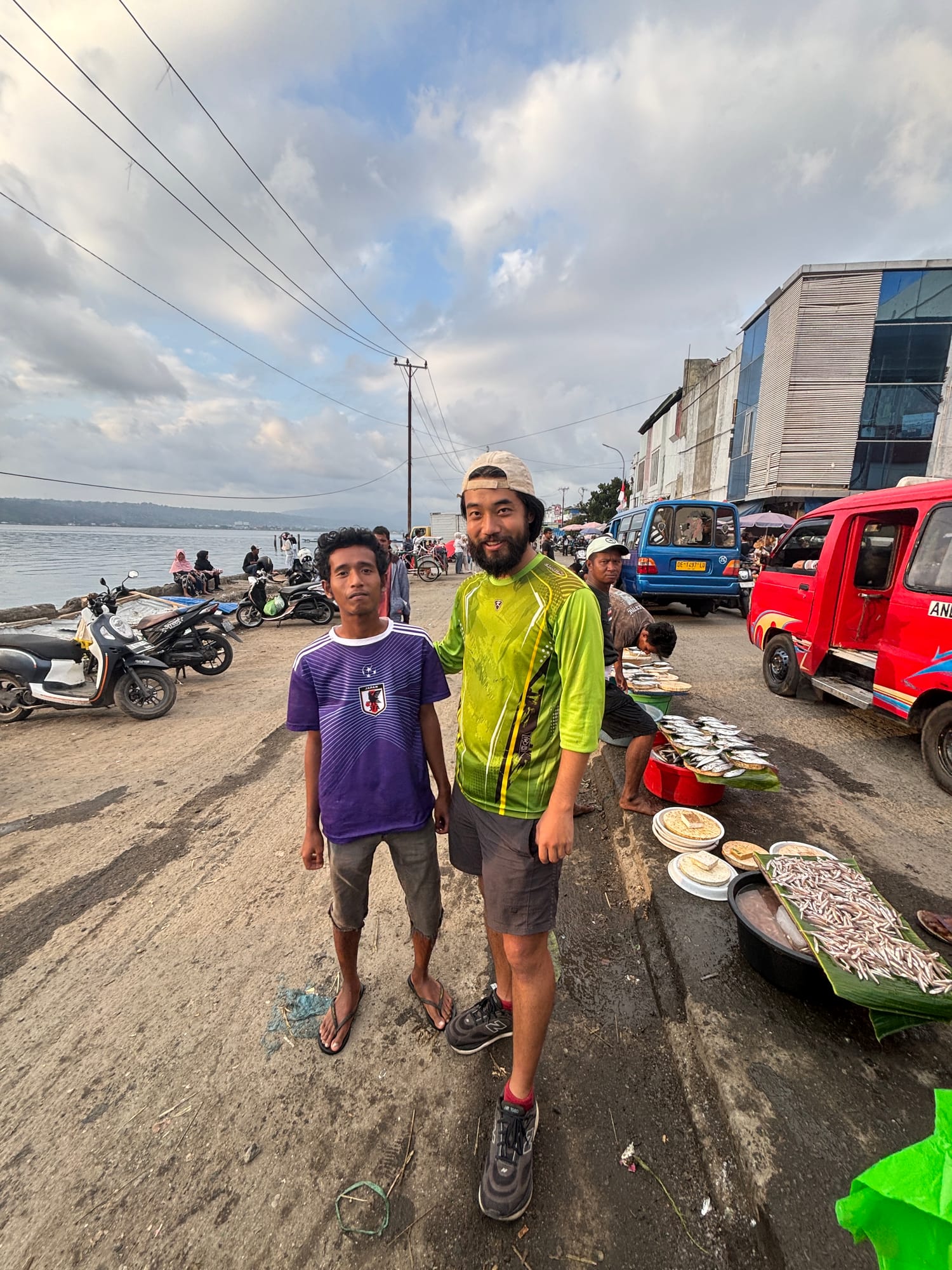 Posing with fish vendors and their catch laid out on plates at the fish market