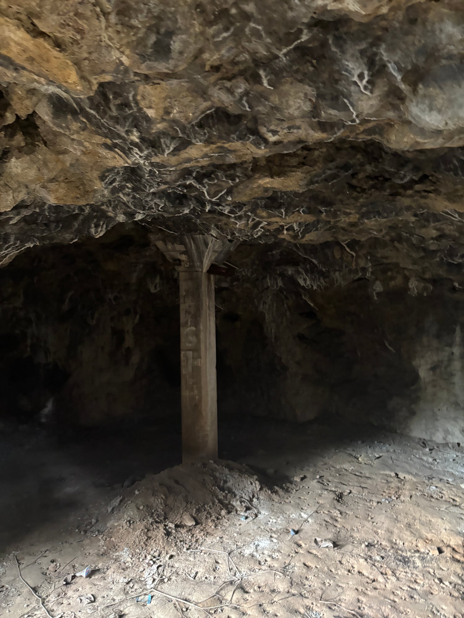 The pitch-black, cave-like interior of the rocky alcove