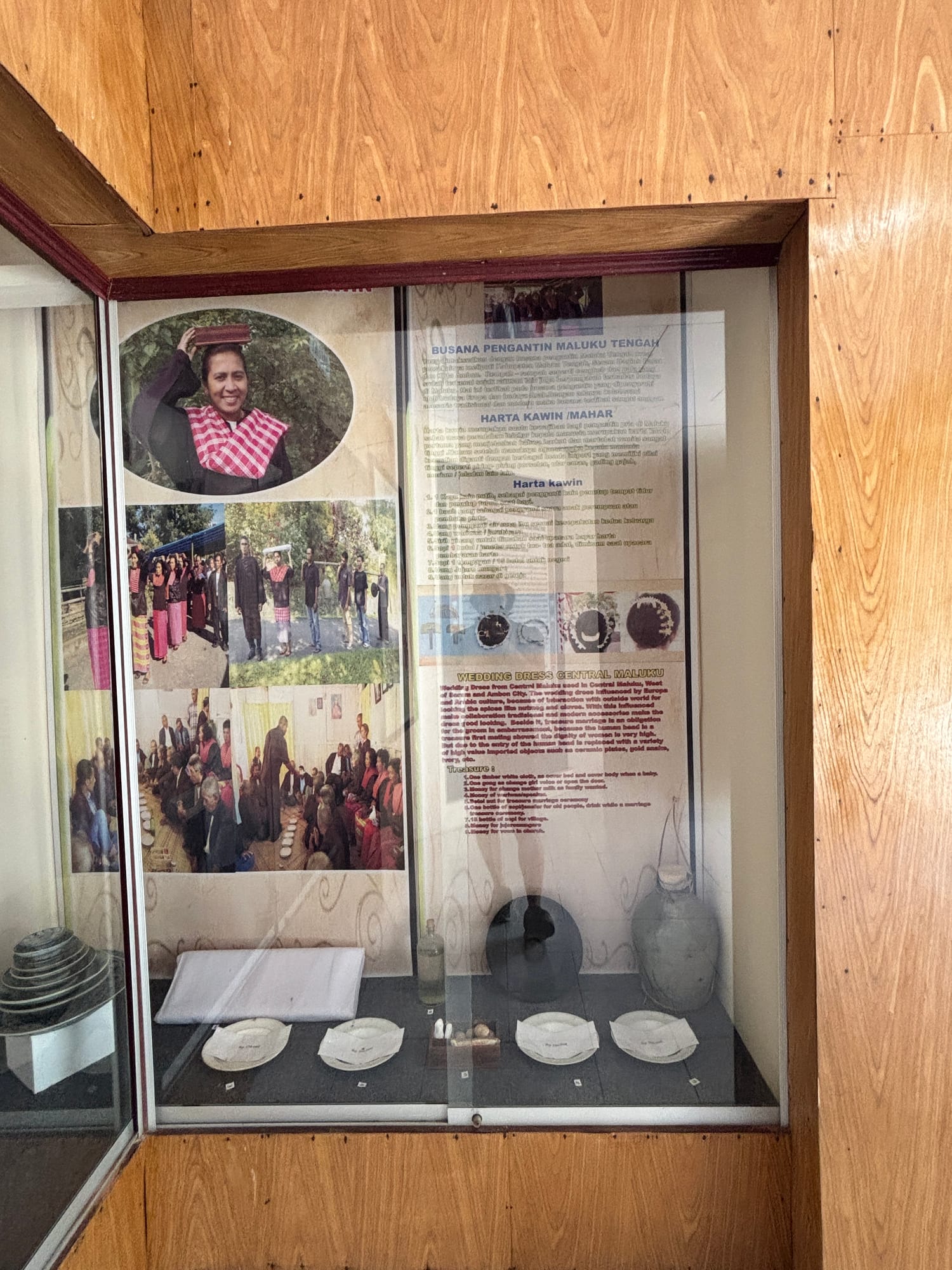 A museum display case with information and photos about traditional Maluku wedding dress