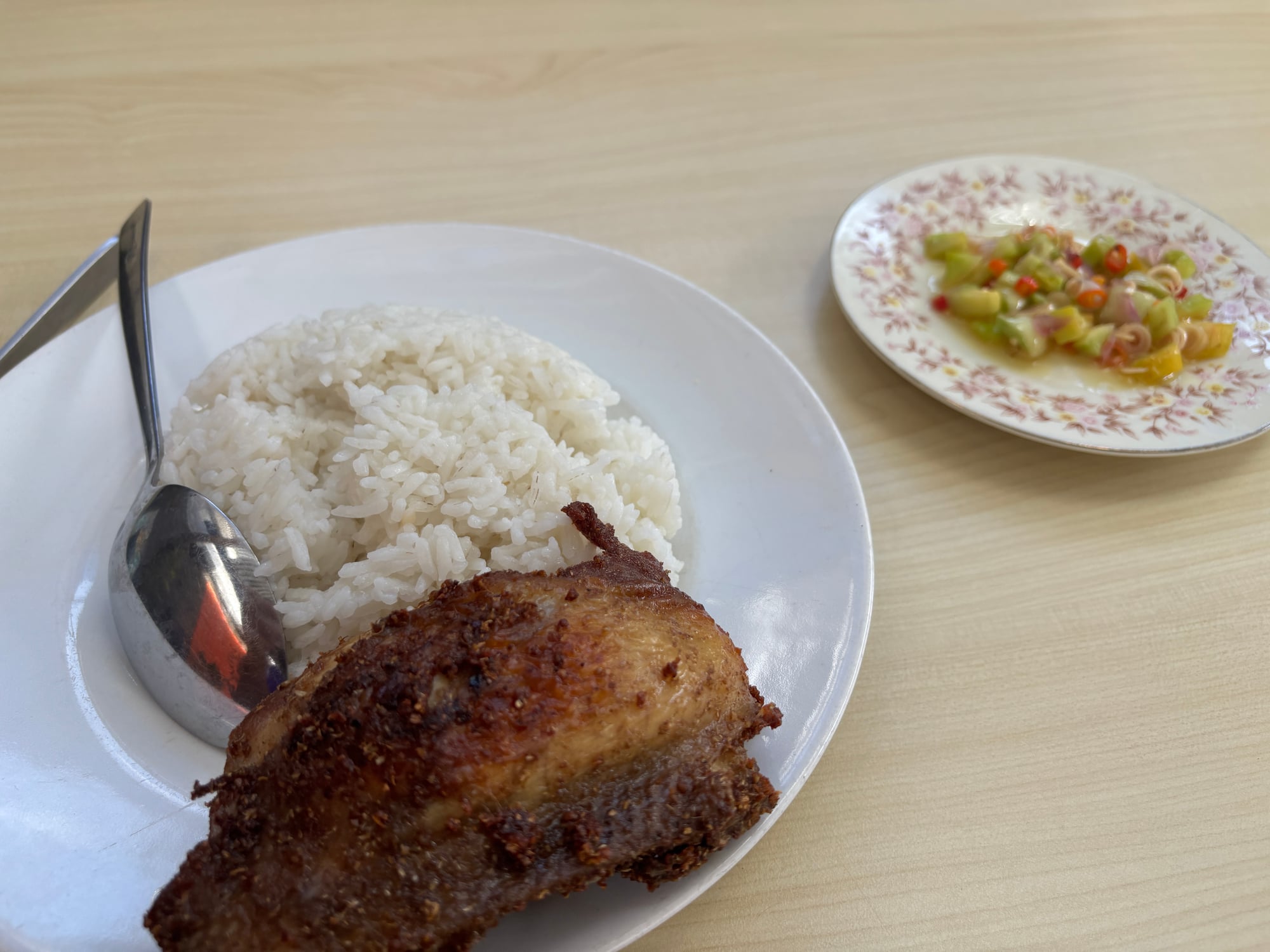 A plate of Nasi Ayam, fried chicken and rice with a side of sambal