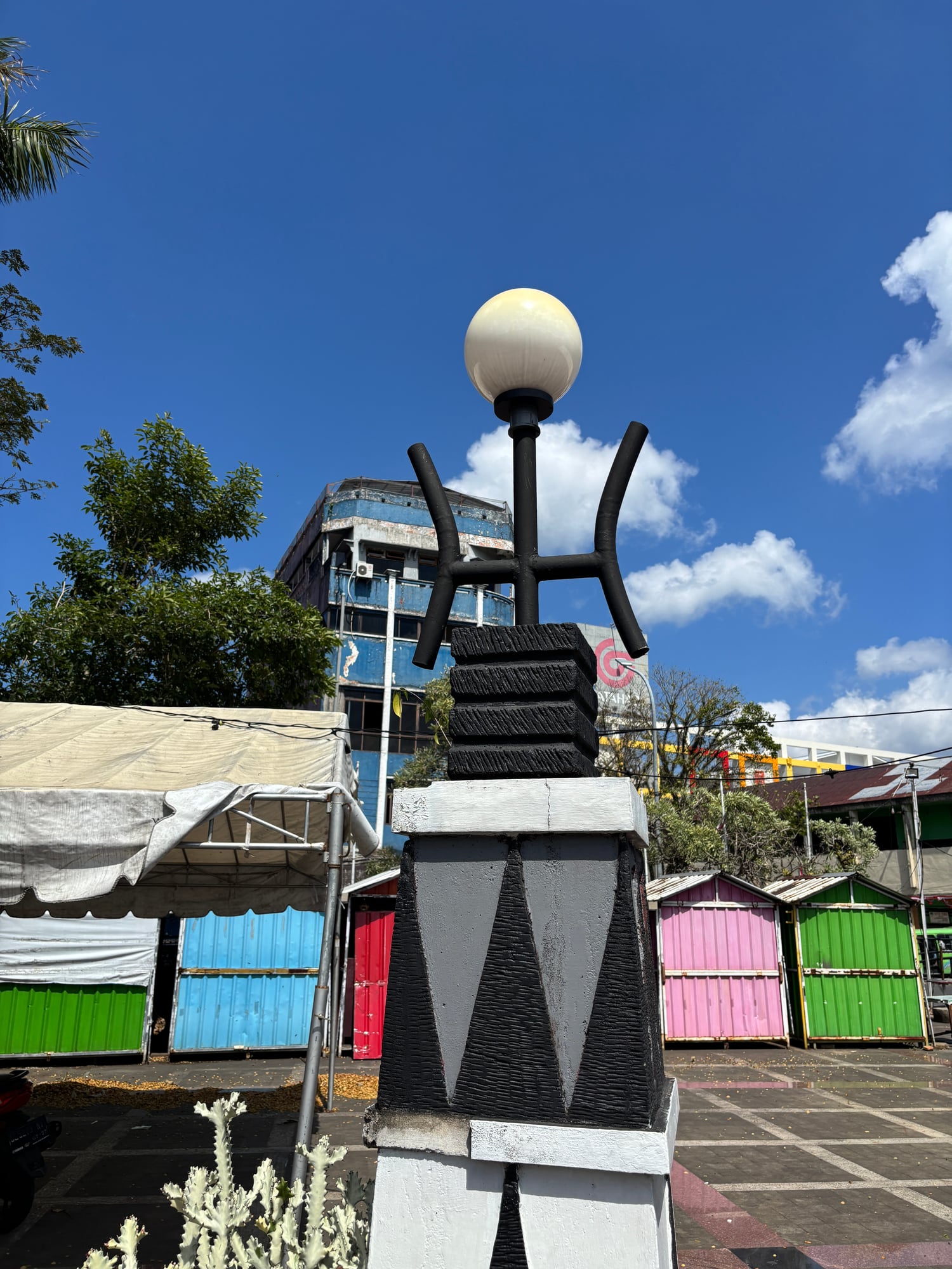 A black-and-white monument with Timor-style motifs near the World Peace Gong