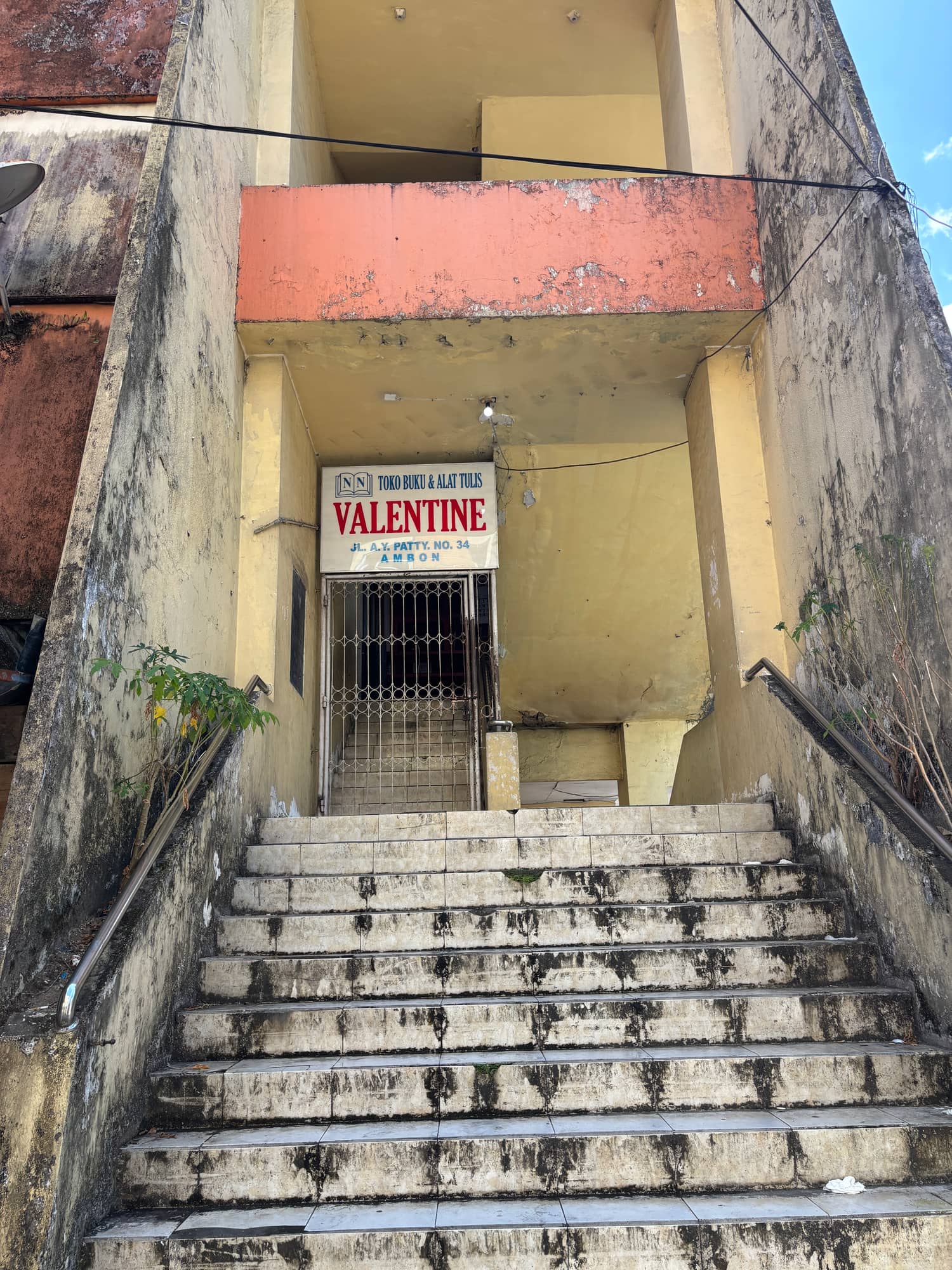 The closed metal gate of a bookstore called Toko Buku Valentine