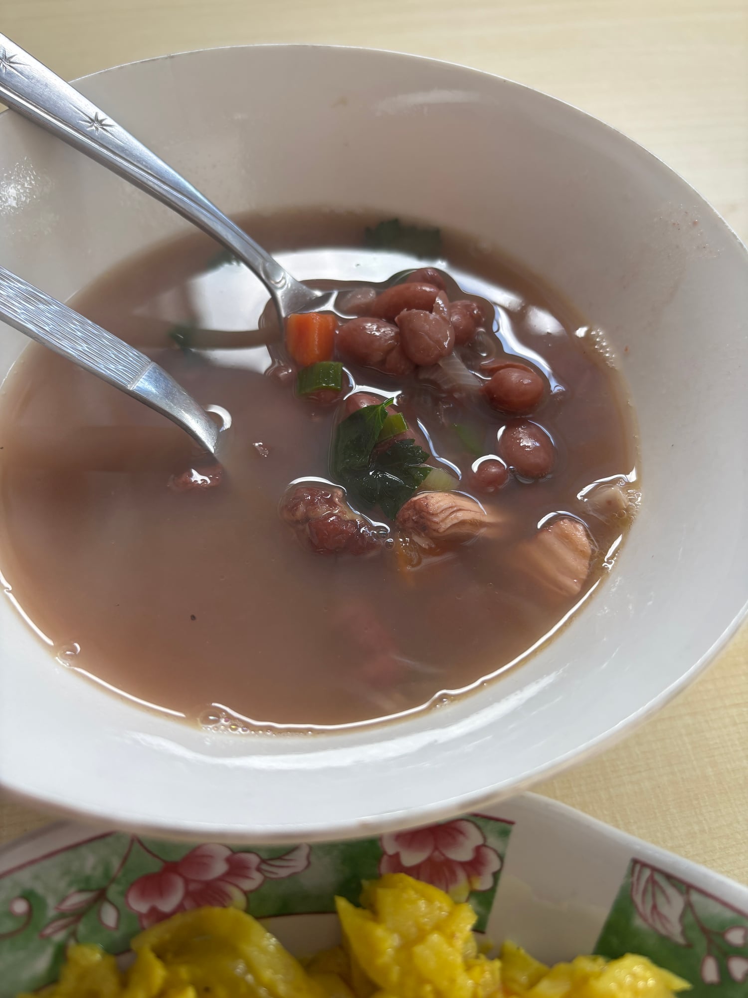 A bowl of red bean soup with chicken and vegetables