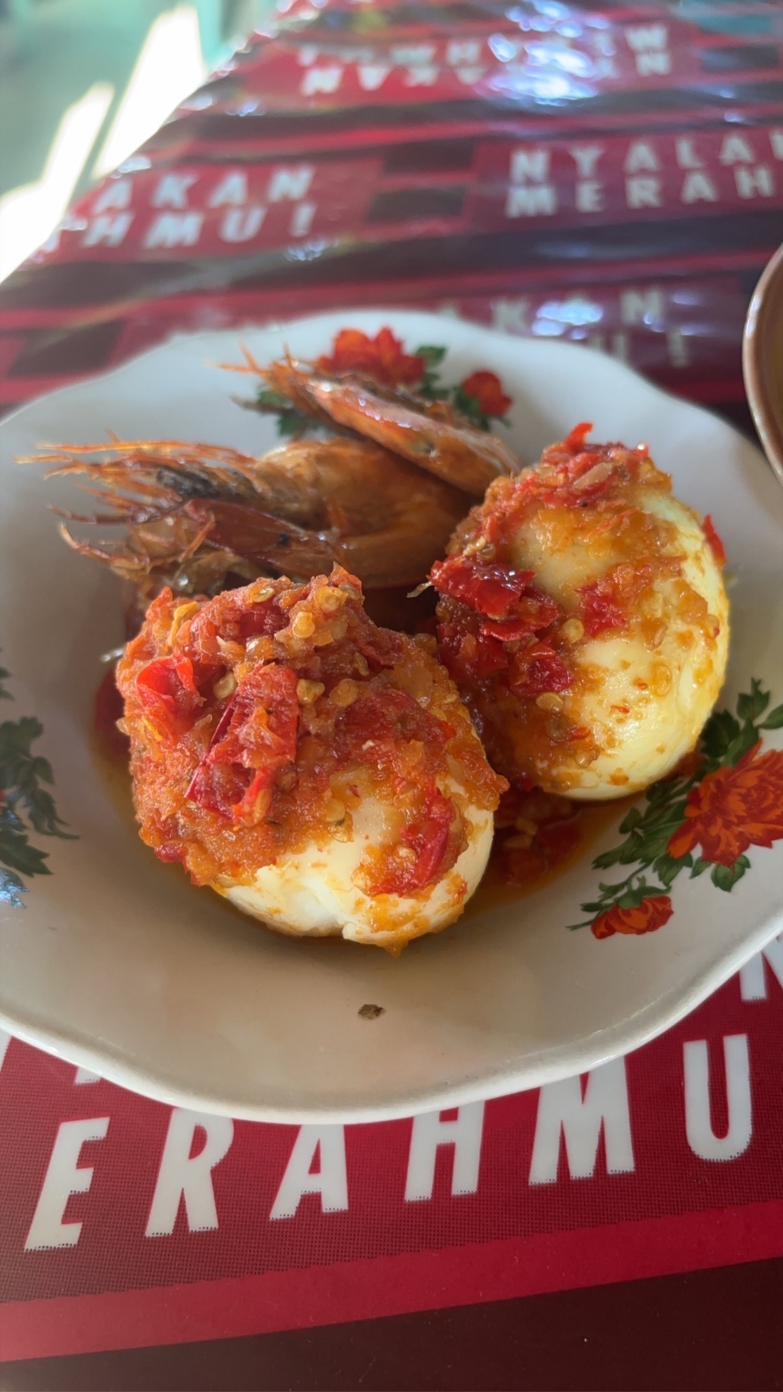 Spicy sambal-covered eggs and shrimp for a fiery breakfast on the bus