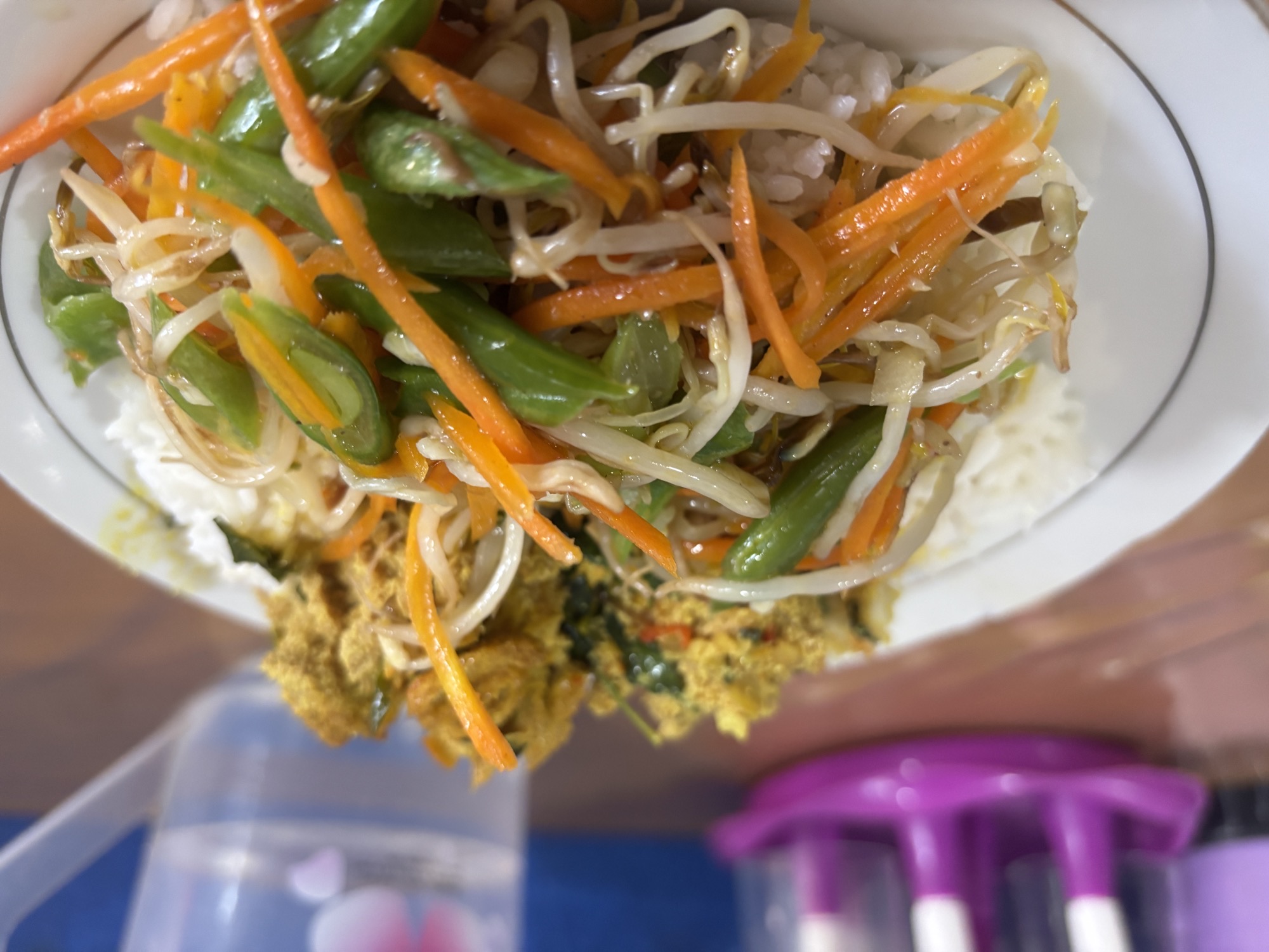 A spicy breakfast plate with rice, vegetables, and a fish roe-like relish
