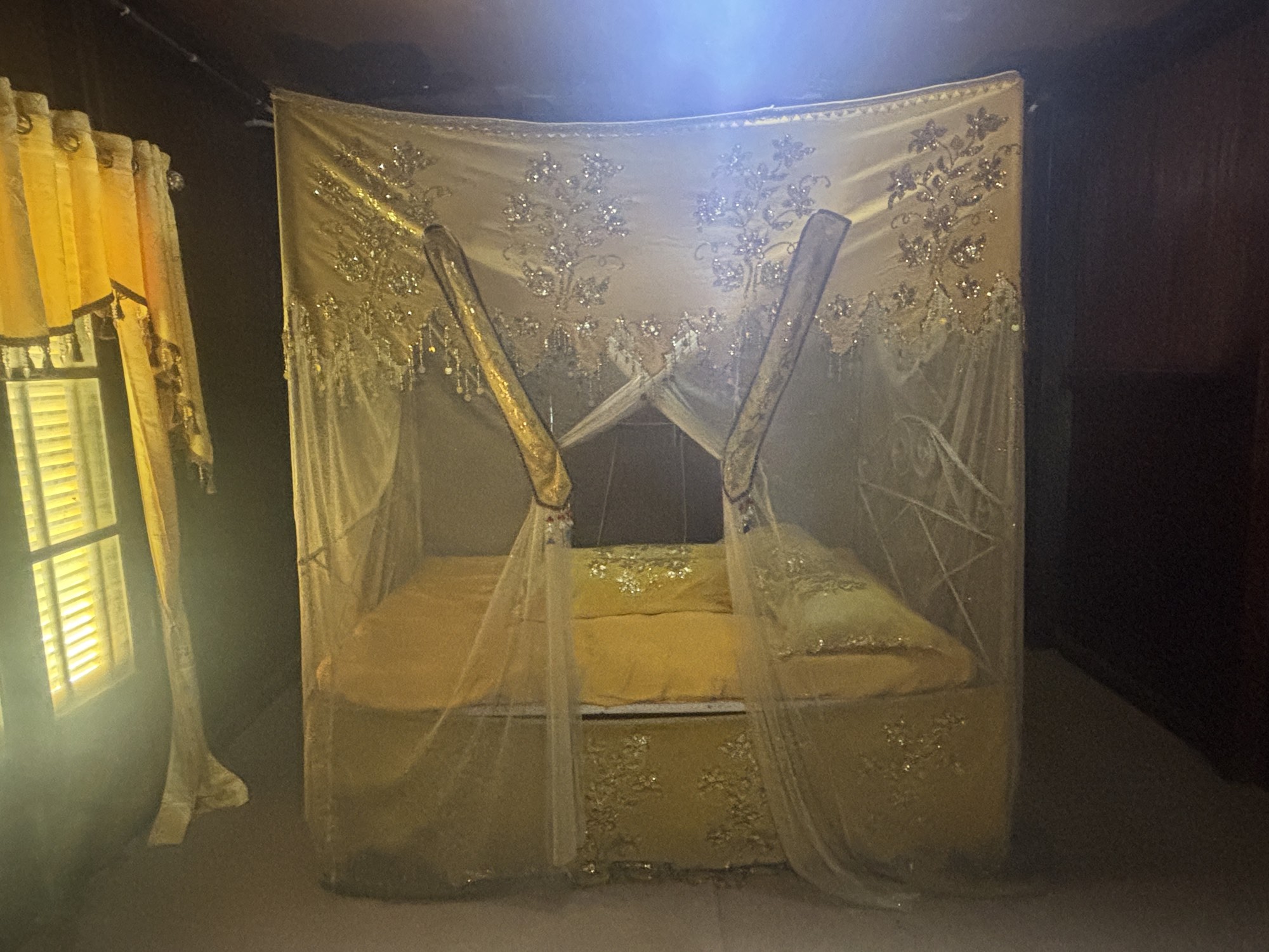 The royal bedroom inside Souraja palace, draped in yellow curtains symbolizing nobility