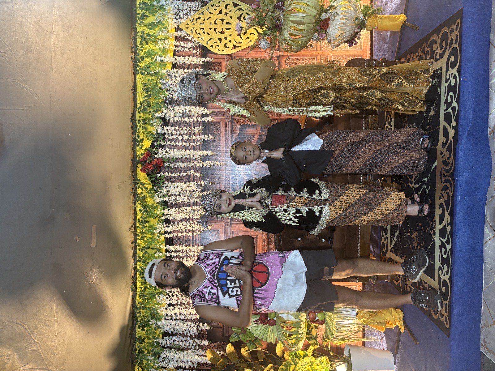 Posing with performers in ornate gold Javanese traditional costumes