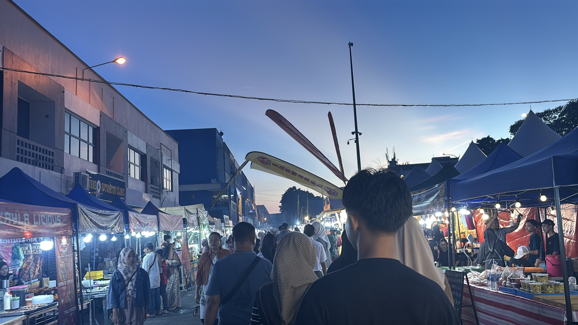Walking through the food stalls of the festival at dusk