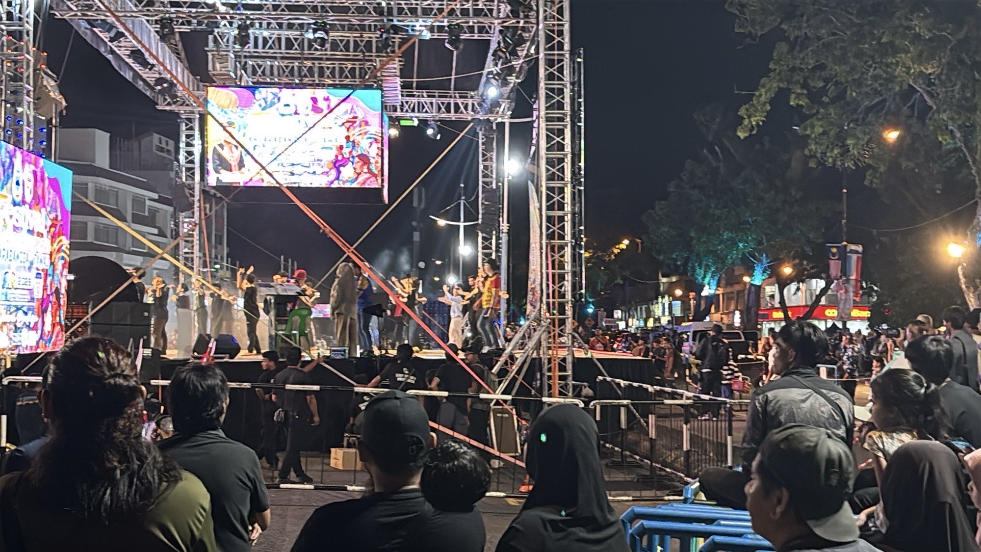 The main festival stage lit up at night with performers and a large crowd