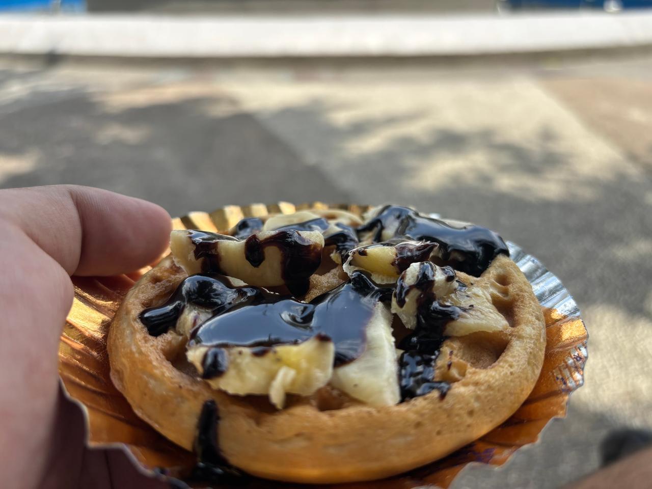 A waffle topped with banana and chocolate sauce