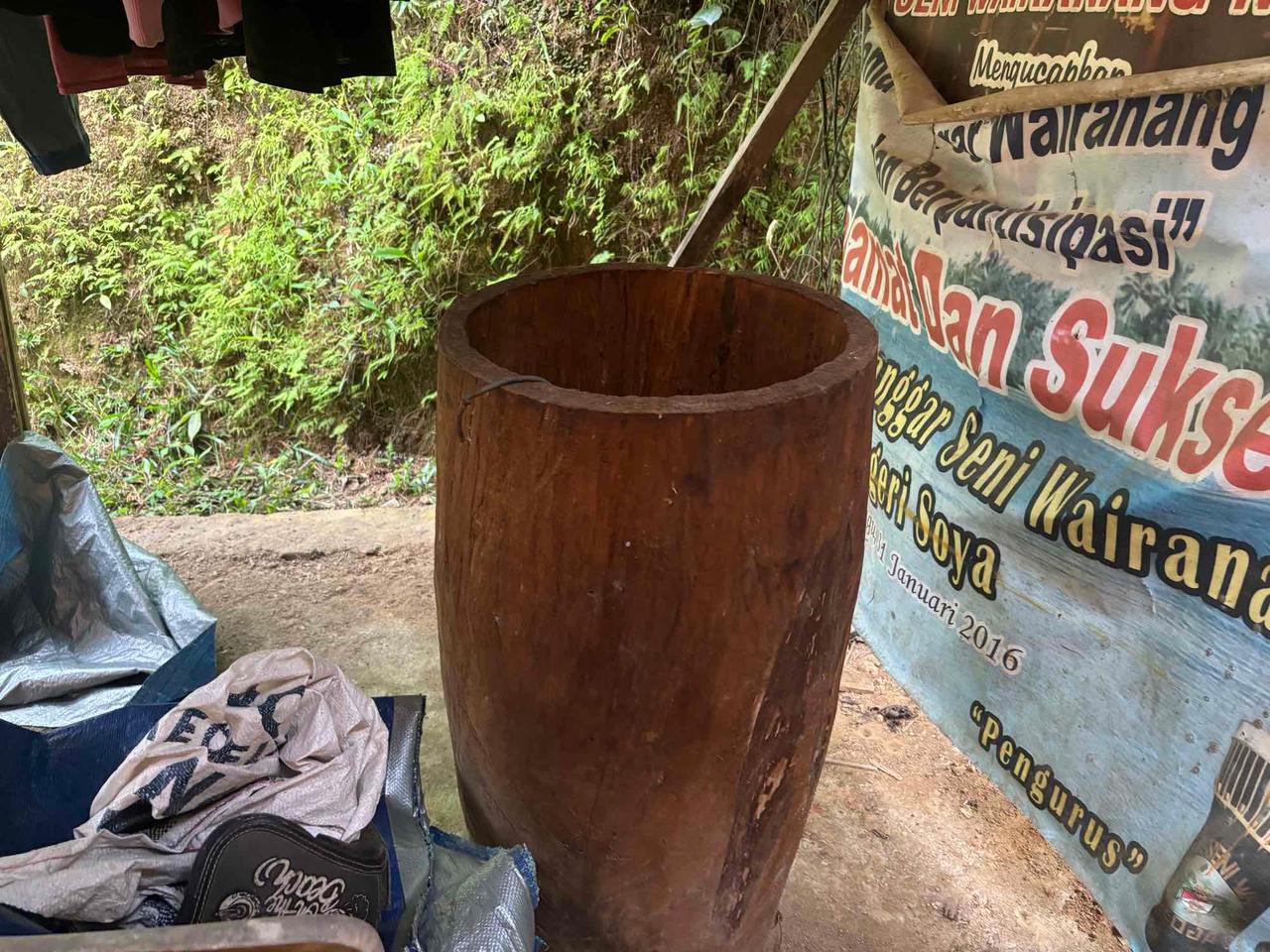 Batang kayu berlubang yang sedang diukir menjadi badan gendang Tifa