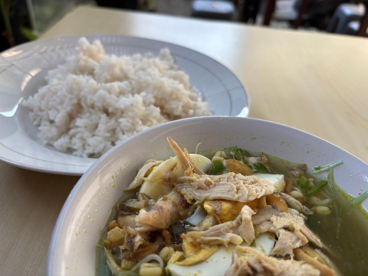 A bowl of Soto Ayam chicken soup with rice from a street food stall in Ambon