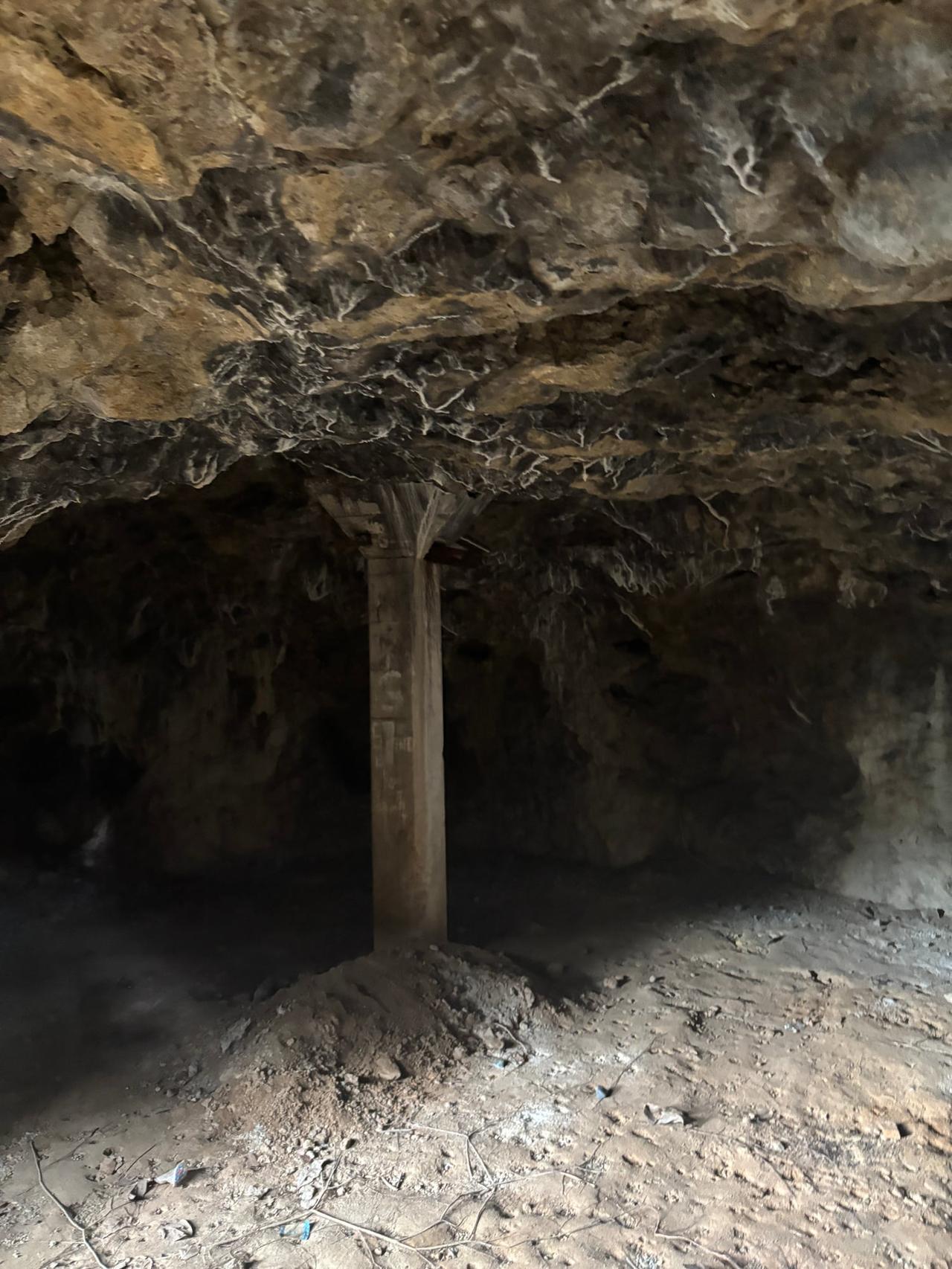 The pitch-black, cave-like interior of the rocky alcove