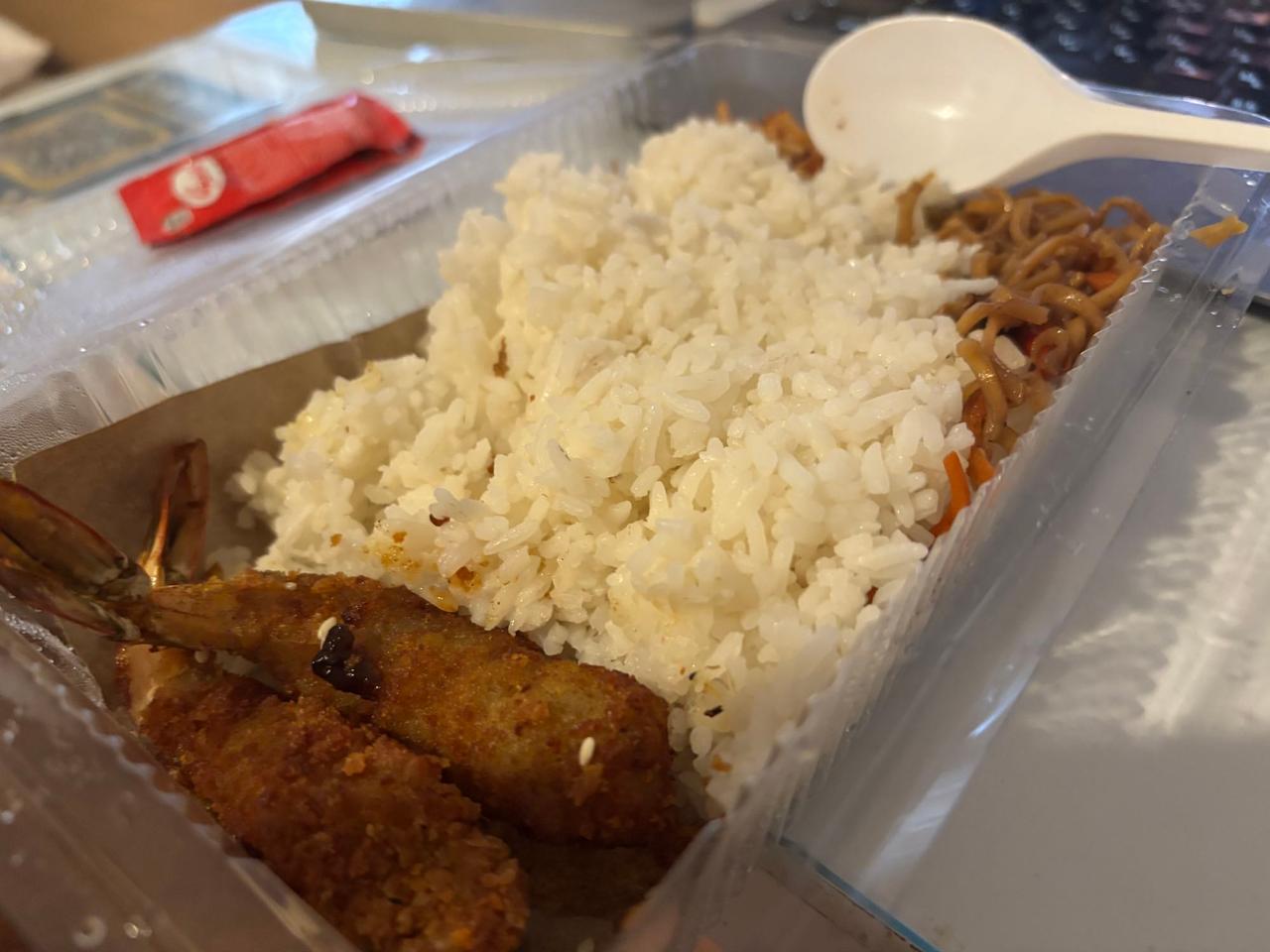 A takeaway box of Udang with rice, fried shrimp, and noodles