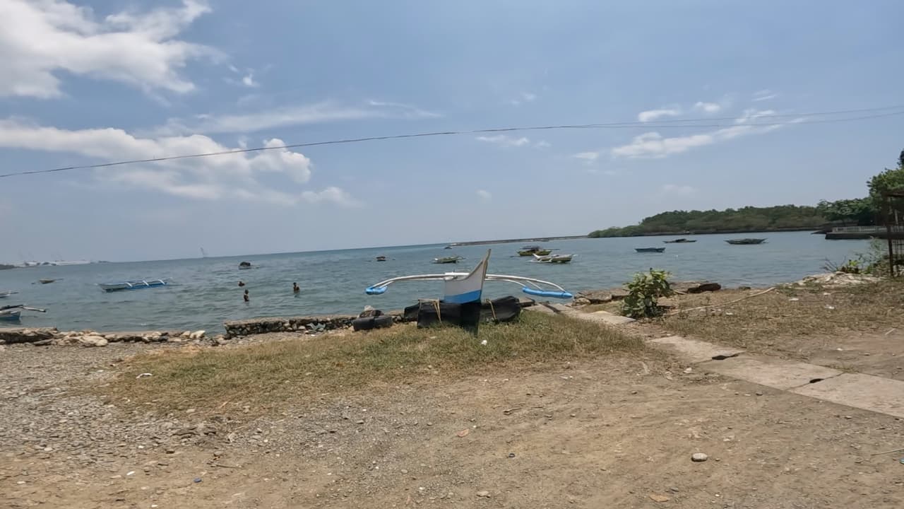 Outrigger bangka boats on the calm Tanon Strait shoreline in Balamban, Cebu