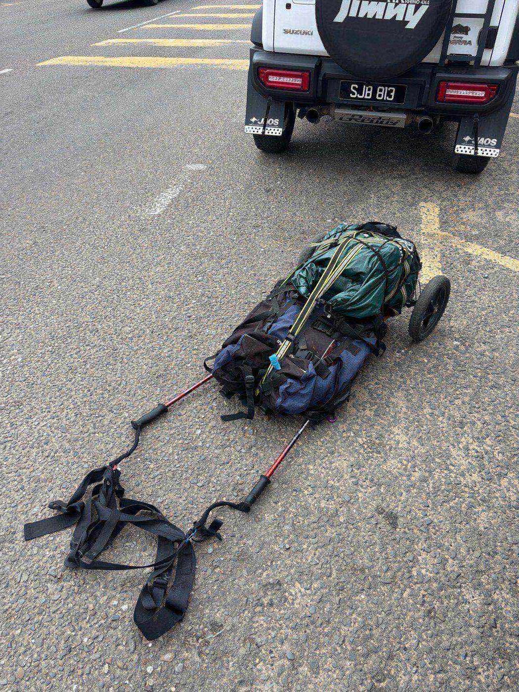 My travel cart parked behind the Suzuki Jimny that gave me a ride
