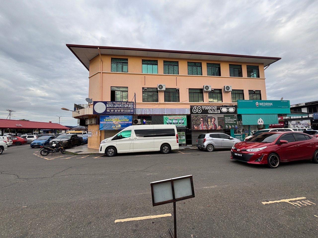A street view of shops and parked cars in Keningau town