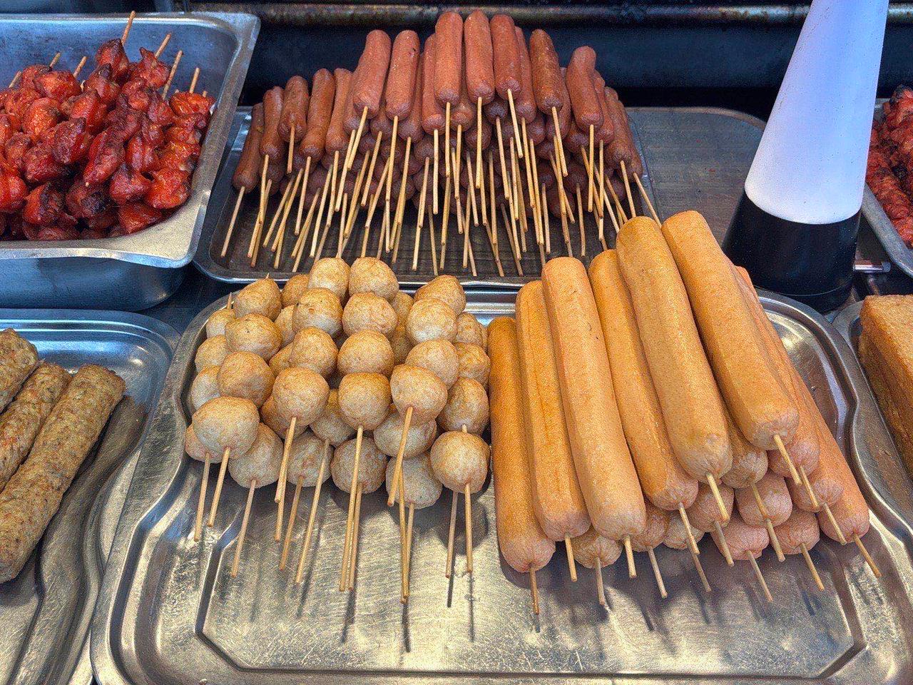 Skewered sausages, fish balls, and fish cakes at a market stall