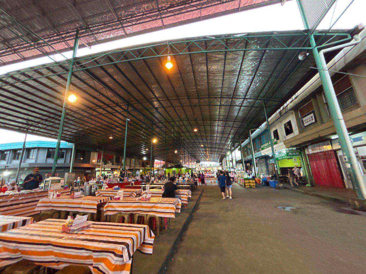 Rows of dining tables under the covered market walkway