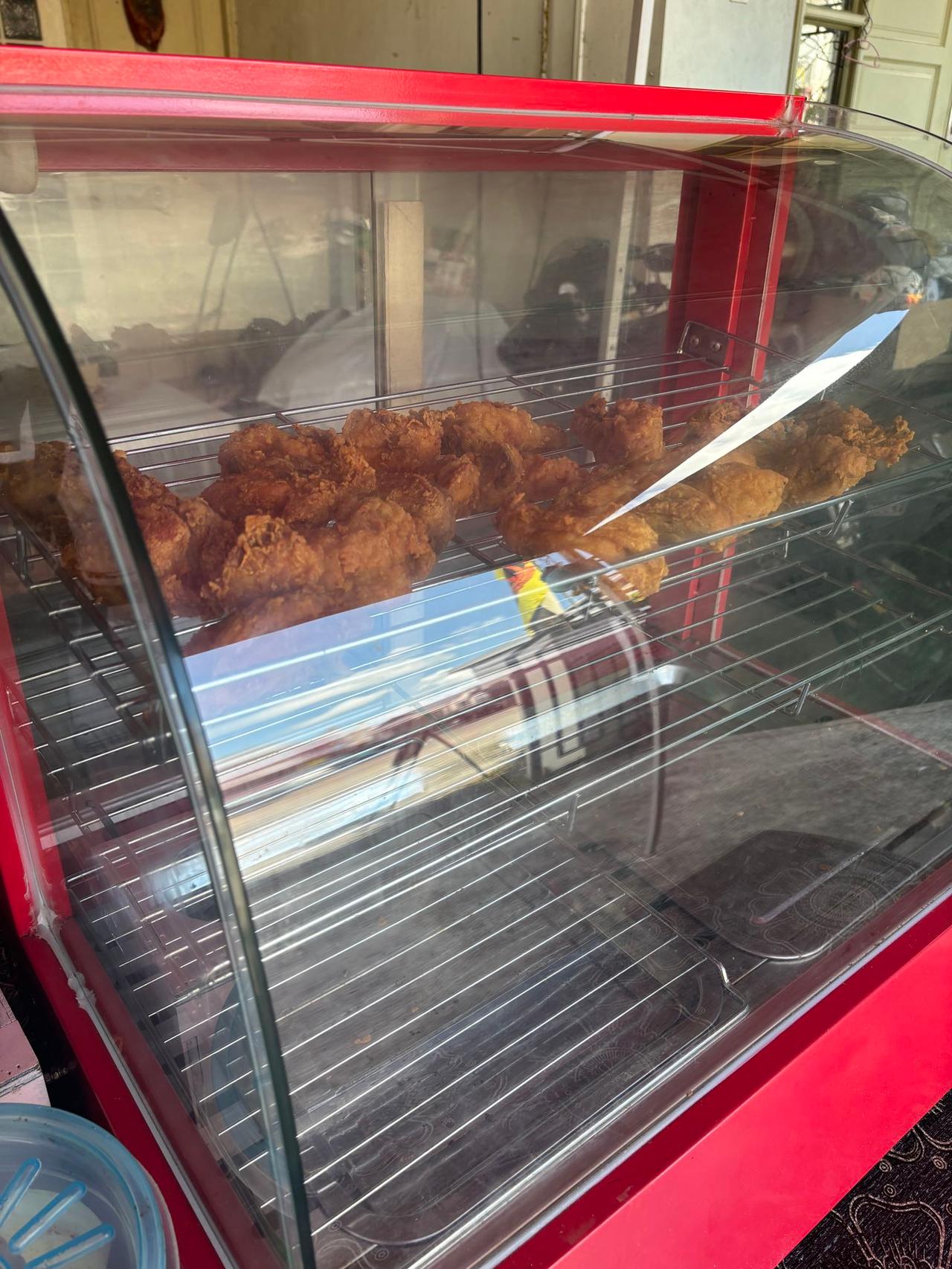 A display case of freshly fried chicken at a Nasi Katok stall