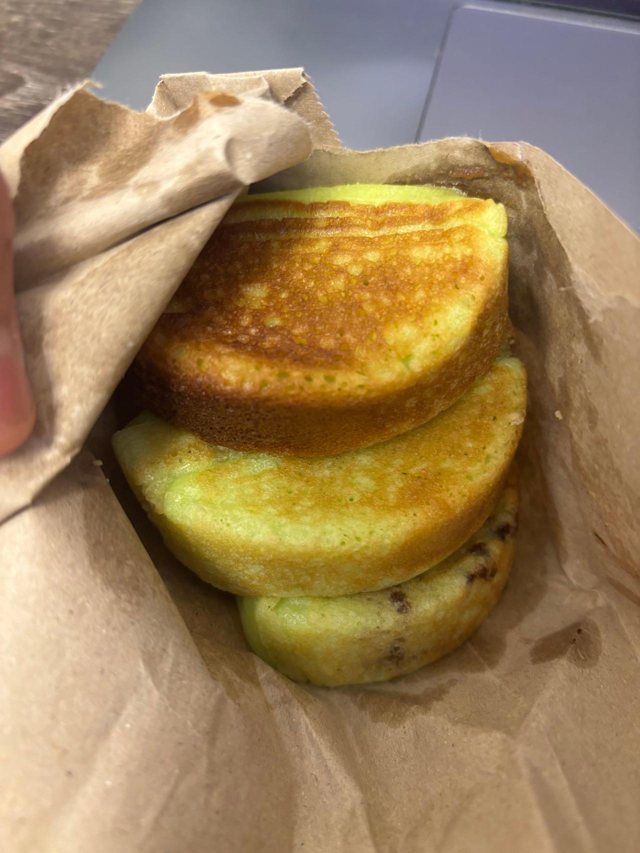 A paper bag holding several freshly made Takis pancakes