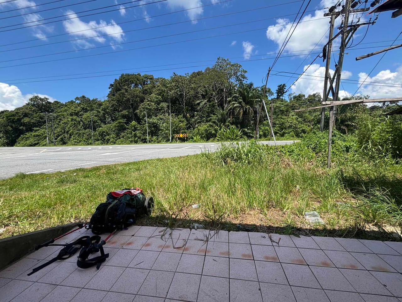Resting with my backpack at a covered bus stop along the road