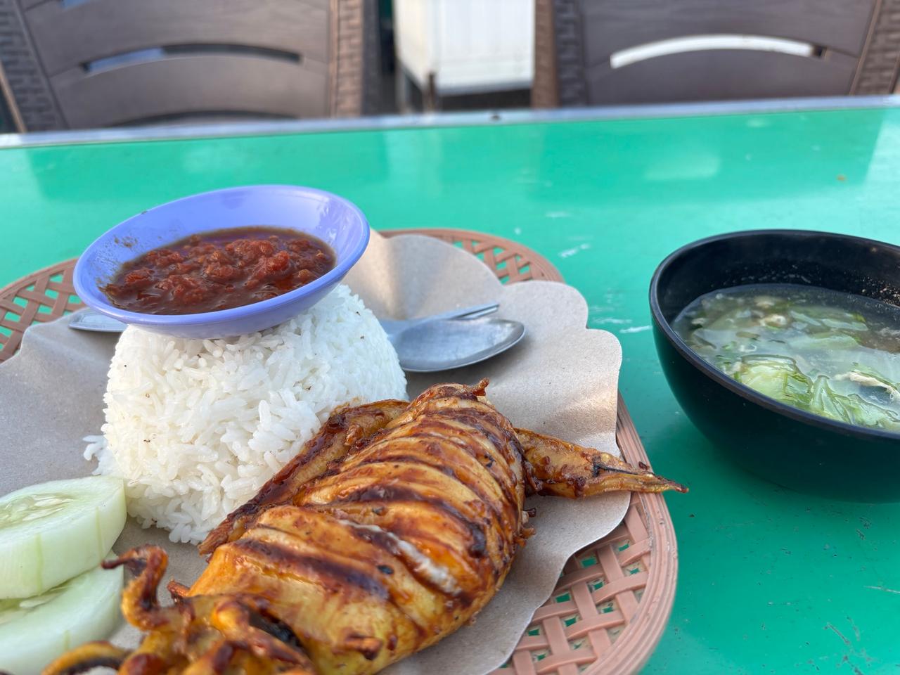 Makan malam cumi-cumi bakar utuh dengan nasi, sambal, dan sup
