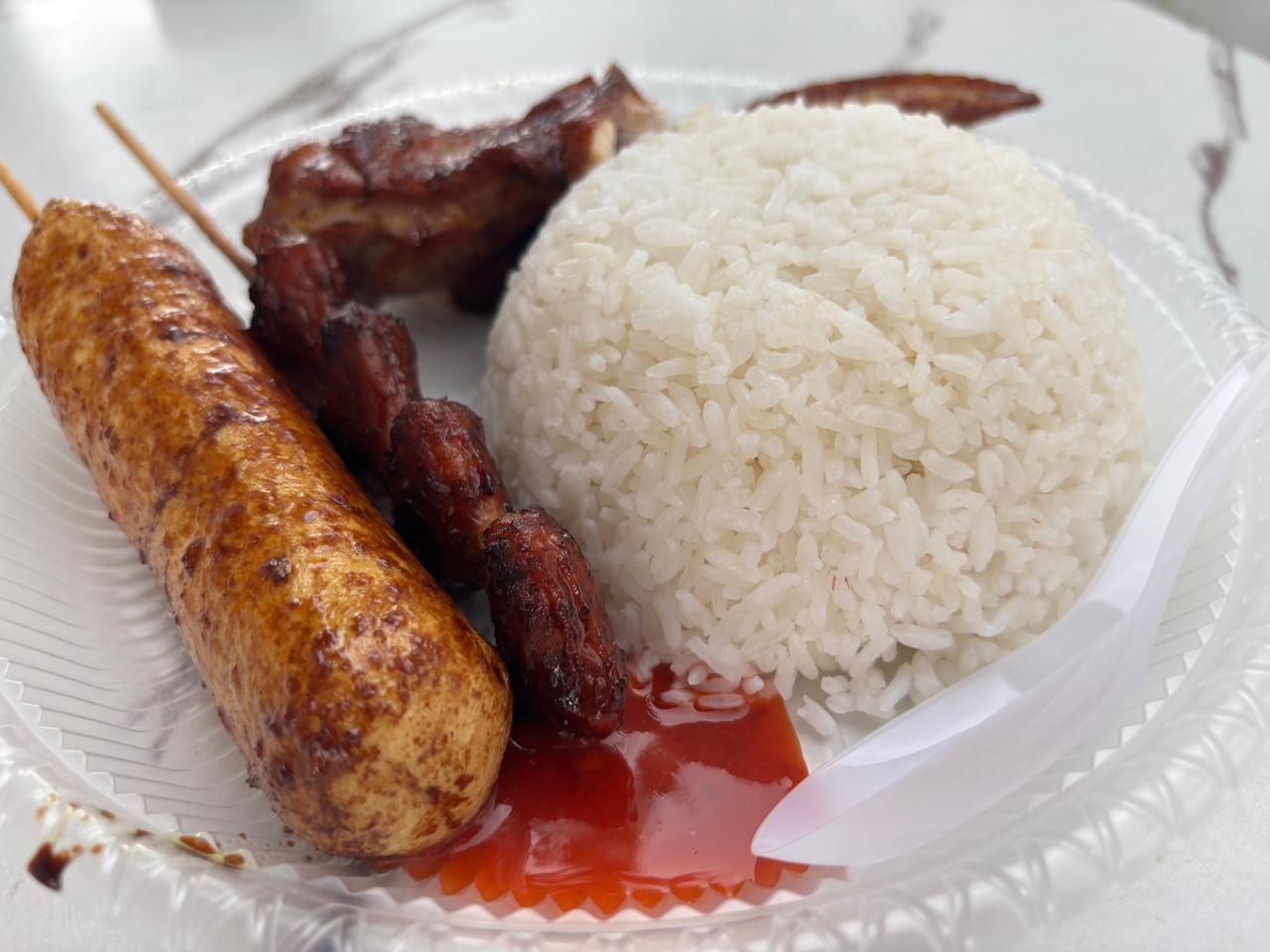 A local lunch spread of meat, chicken tail, and fish dishes