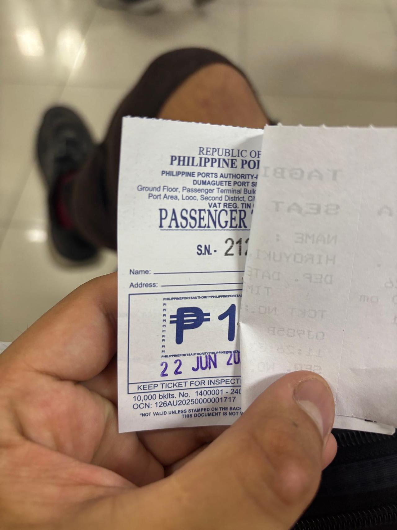 A hand holding a Philippine Ports Authority passenger terminal fee ticket