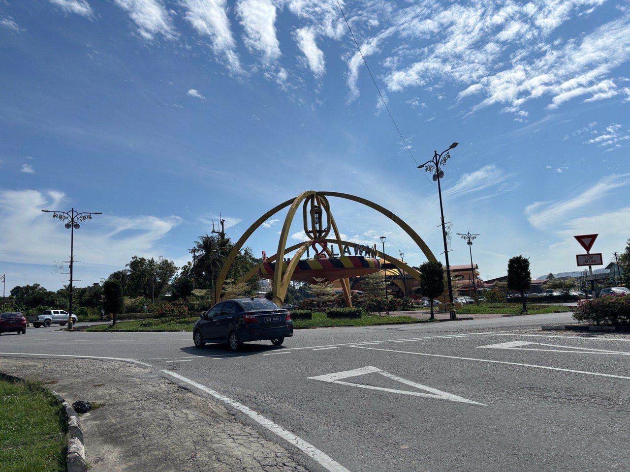 A decorative arch reading "I Love Lawas" over a roundabout