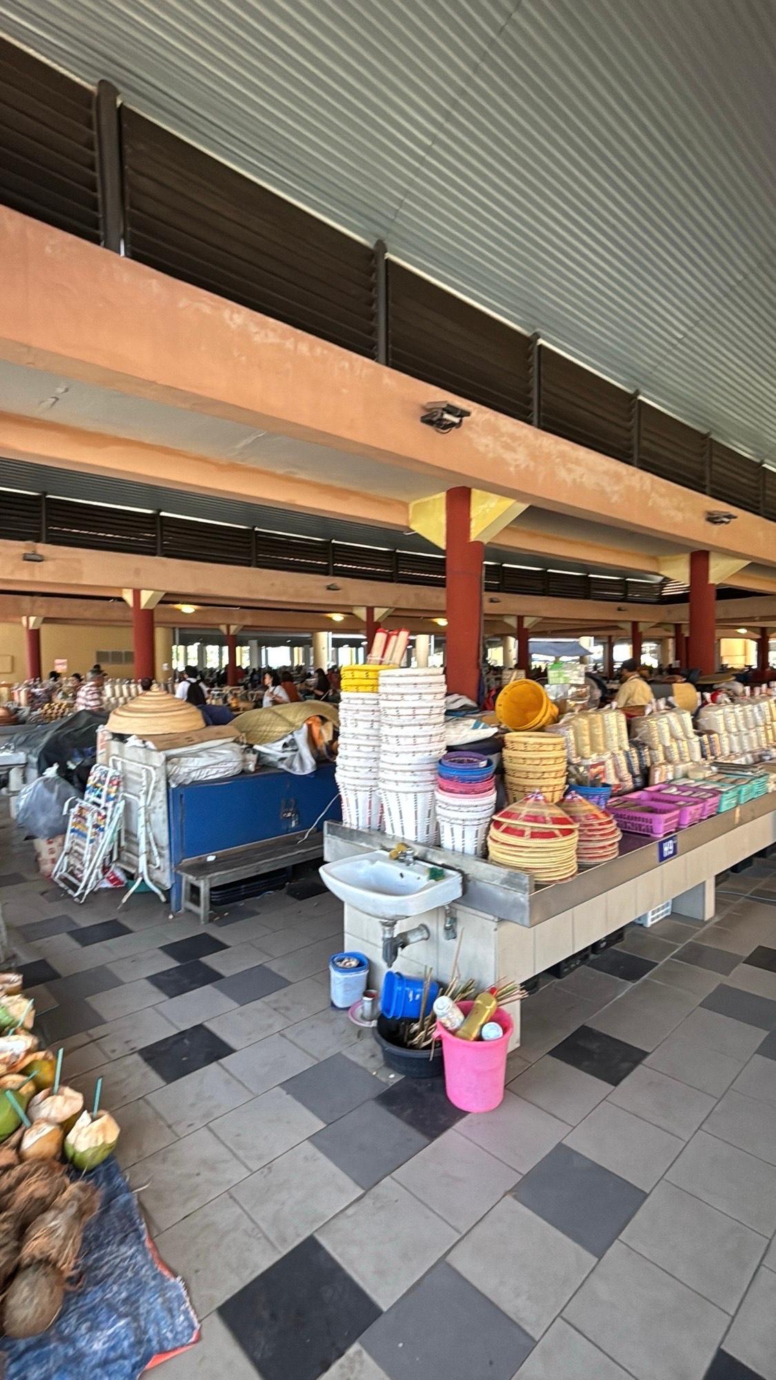 Stalls stacked with baskets and goods inside the covered Saturday Market