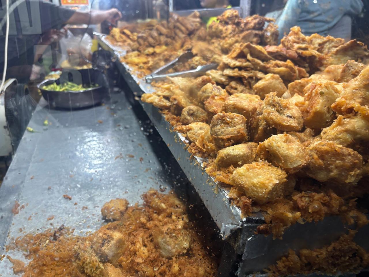 Nampan-nampan berisi tahu goreng, pisang, dan camilan goreng lainnya di lapak pasar malam