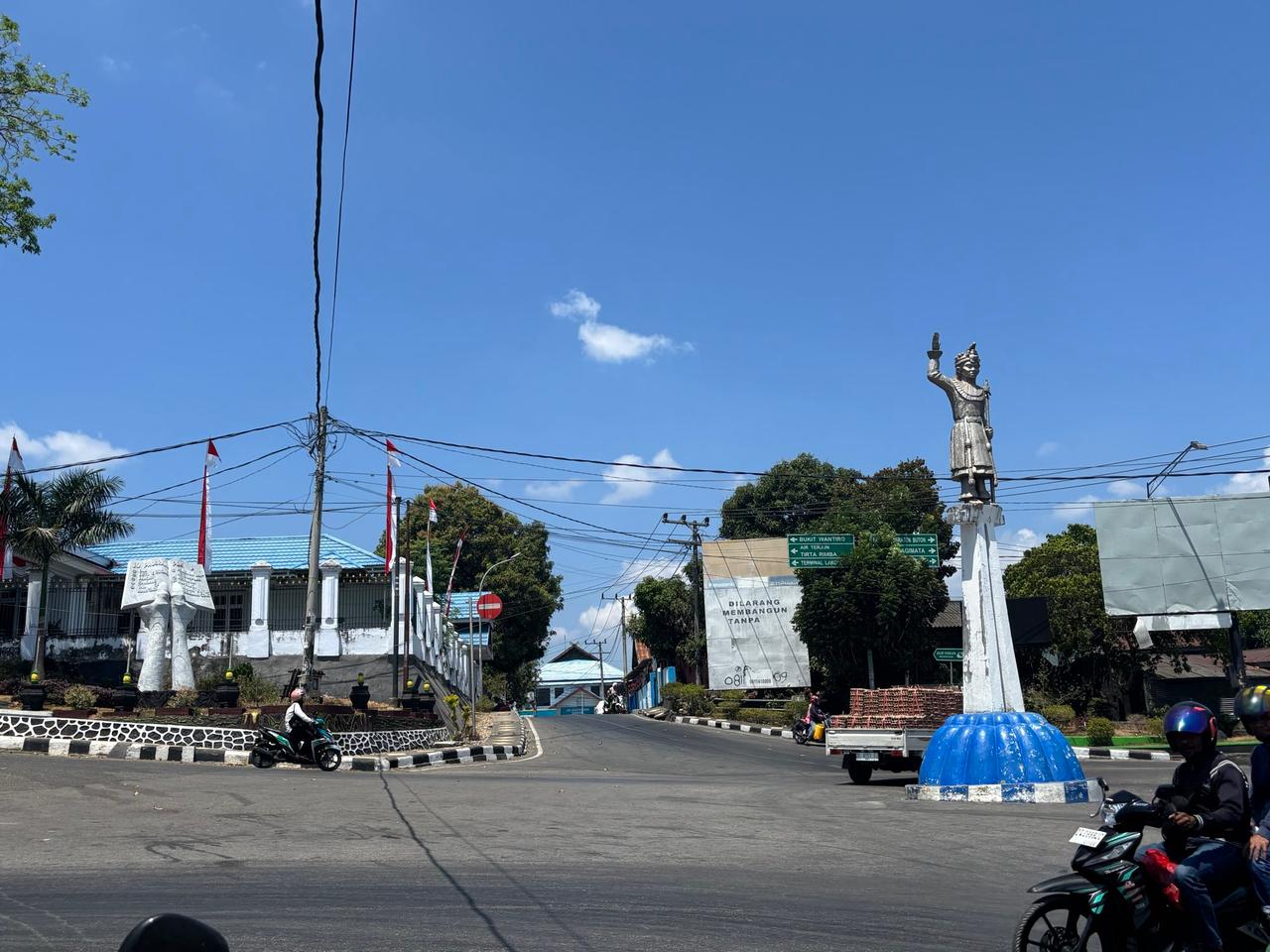 Sebuah jalan di dekat pelabuhan Baubau dengan papan penunjuk arah ke tujuan-tujuan lokal