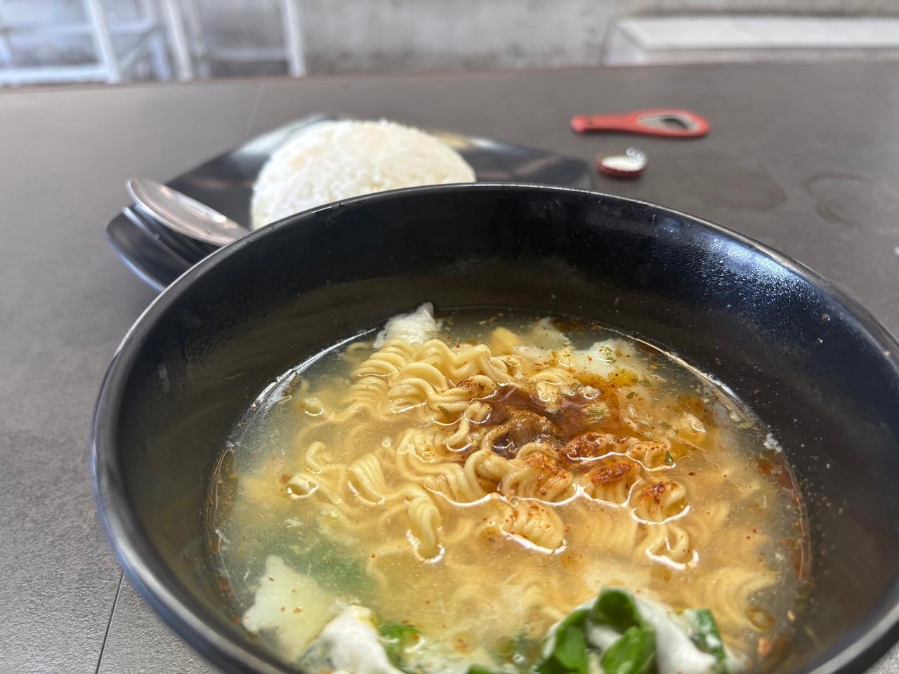 Semangkuk Indomie kuah dengan nasi sebagai pelengkap