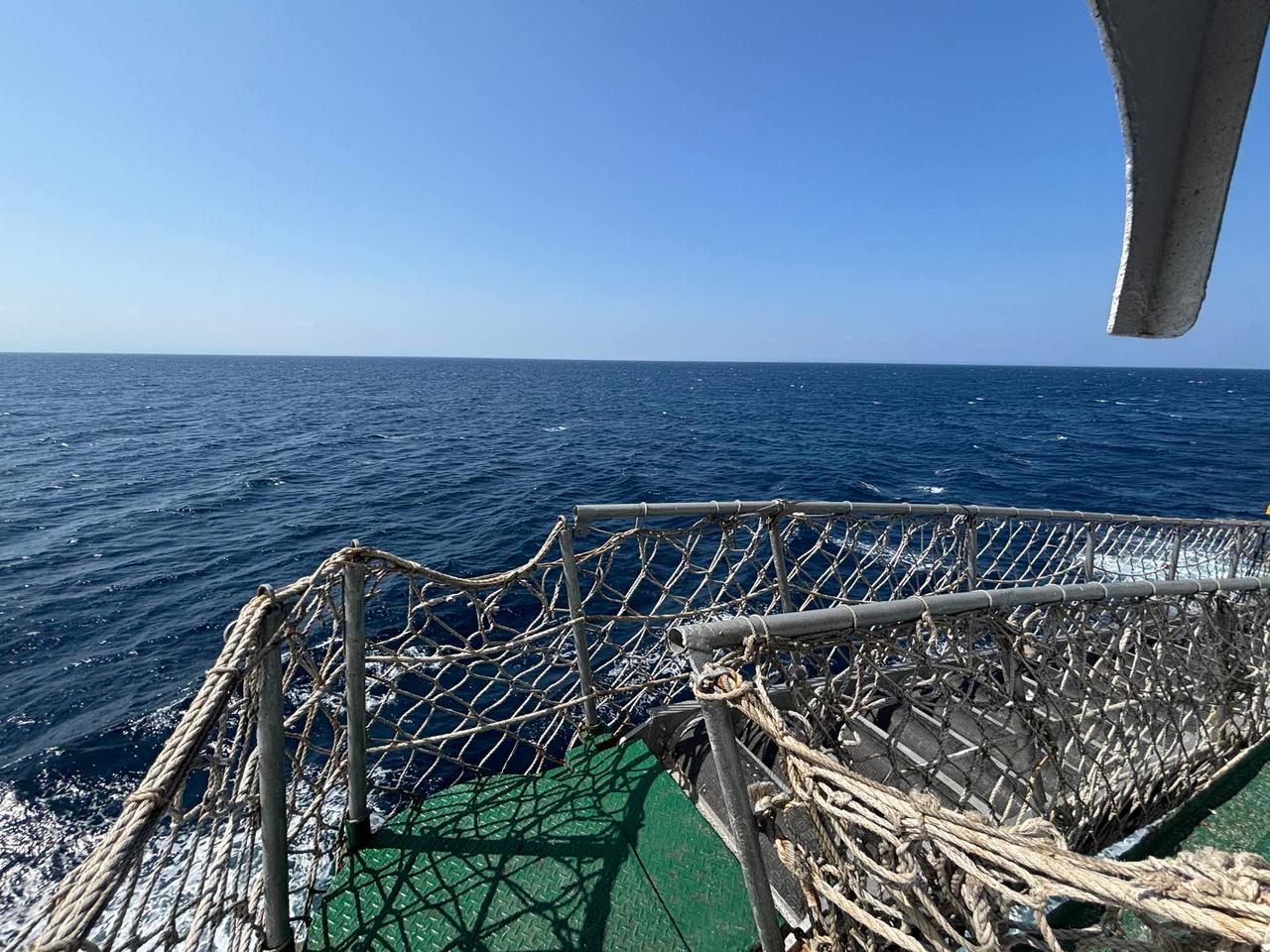 Laut lepas yang terlihat dari dek buritan berjaring tali feri Pelni di bawah langit biru cerah