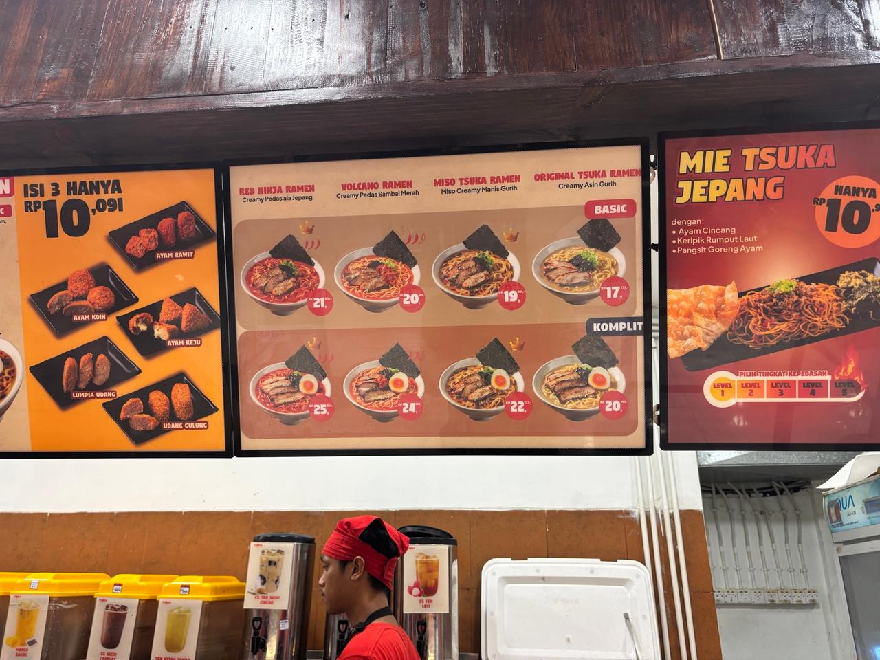 Papan menu bercahaya dari sebuah kedai ramen Jepang di Makassar yang menampilkan foto mangkuk dan harga dalam rupiah