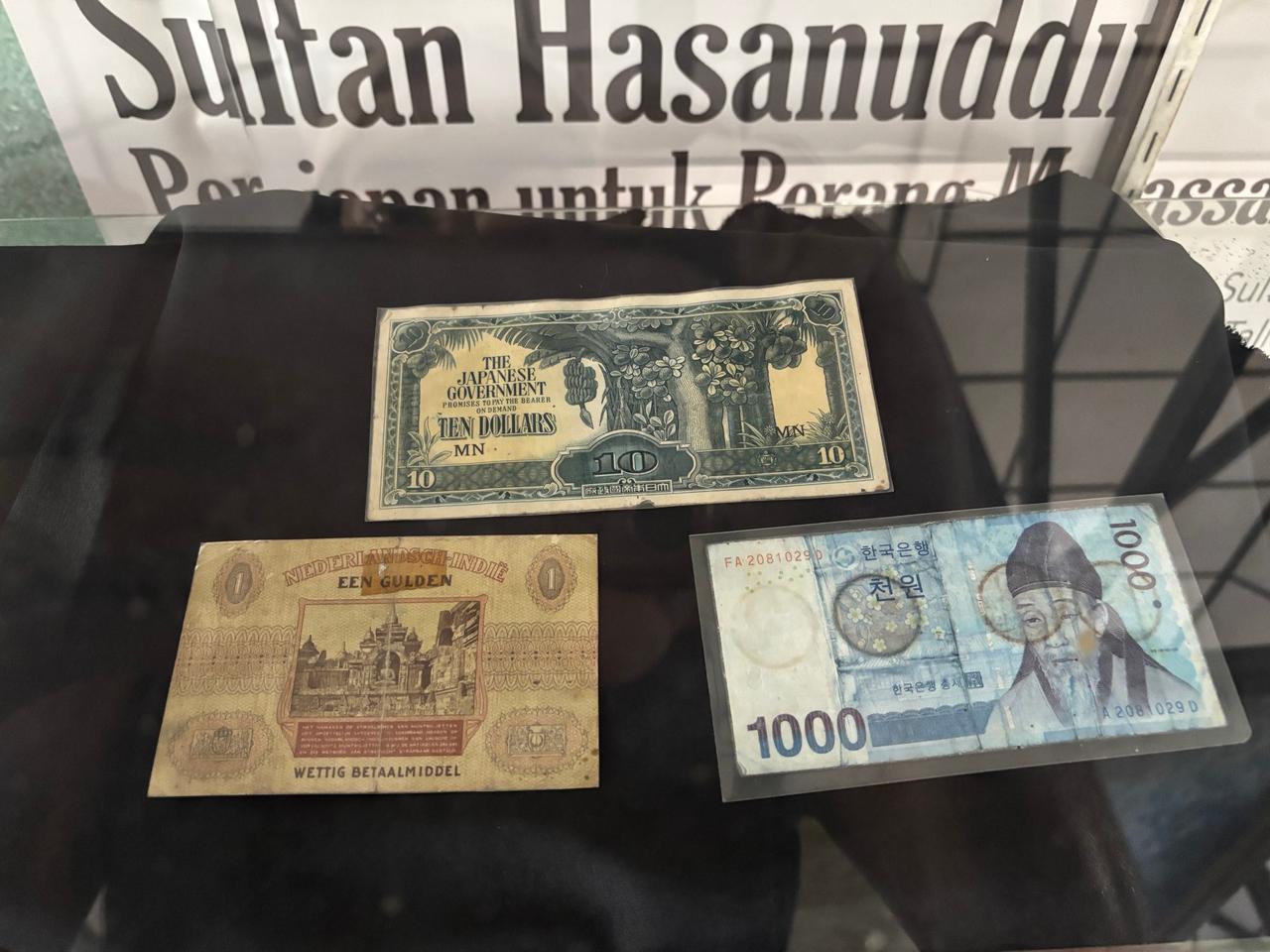 Sebuah lemari kaca berisi uang kertas lama, termasuk dolar masa perang Jepang, gulden kolonial Belanda, dan lembaran won Korea