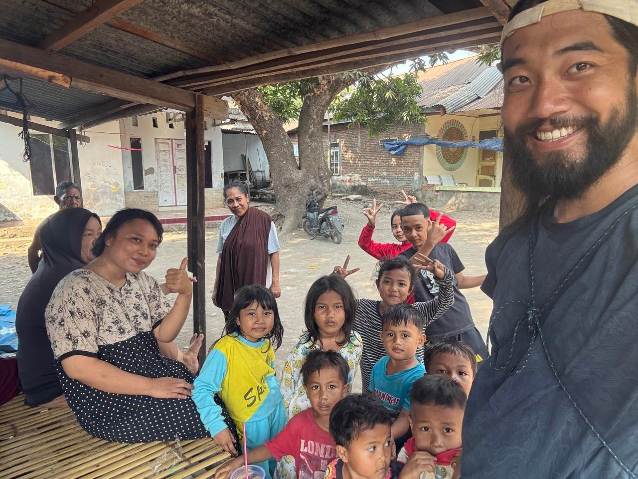 Foto bersama warga desa setempat dan anak-anak yang memberi tanda peace di dalam perkampungan hidup benteng ini