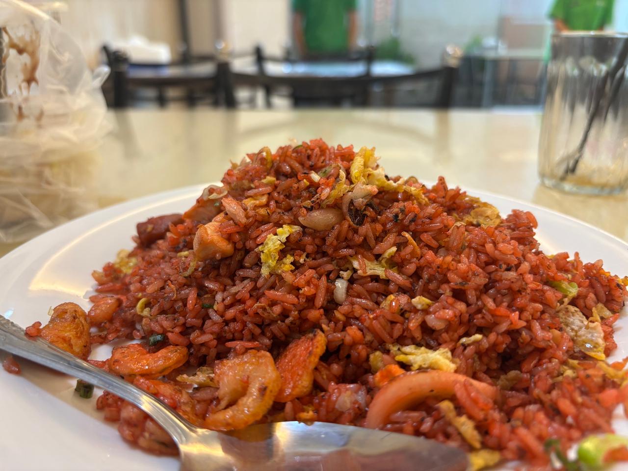 Sepiring nasi goreng seafood dengan udang dan cumi, disajikan di tepi laut