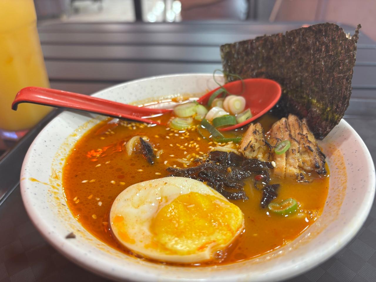 Semangkuk Ninja Ramen pedas dengan kuah kemerahan, telur setengah matang, ayam panggang, dan nori