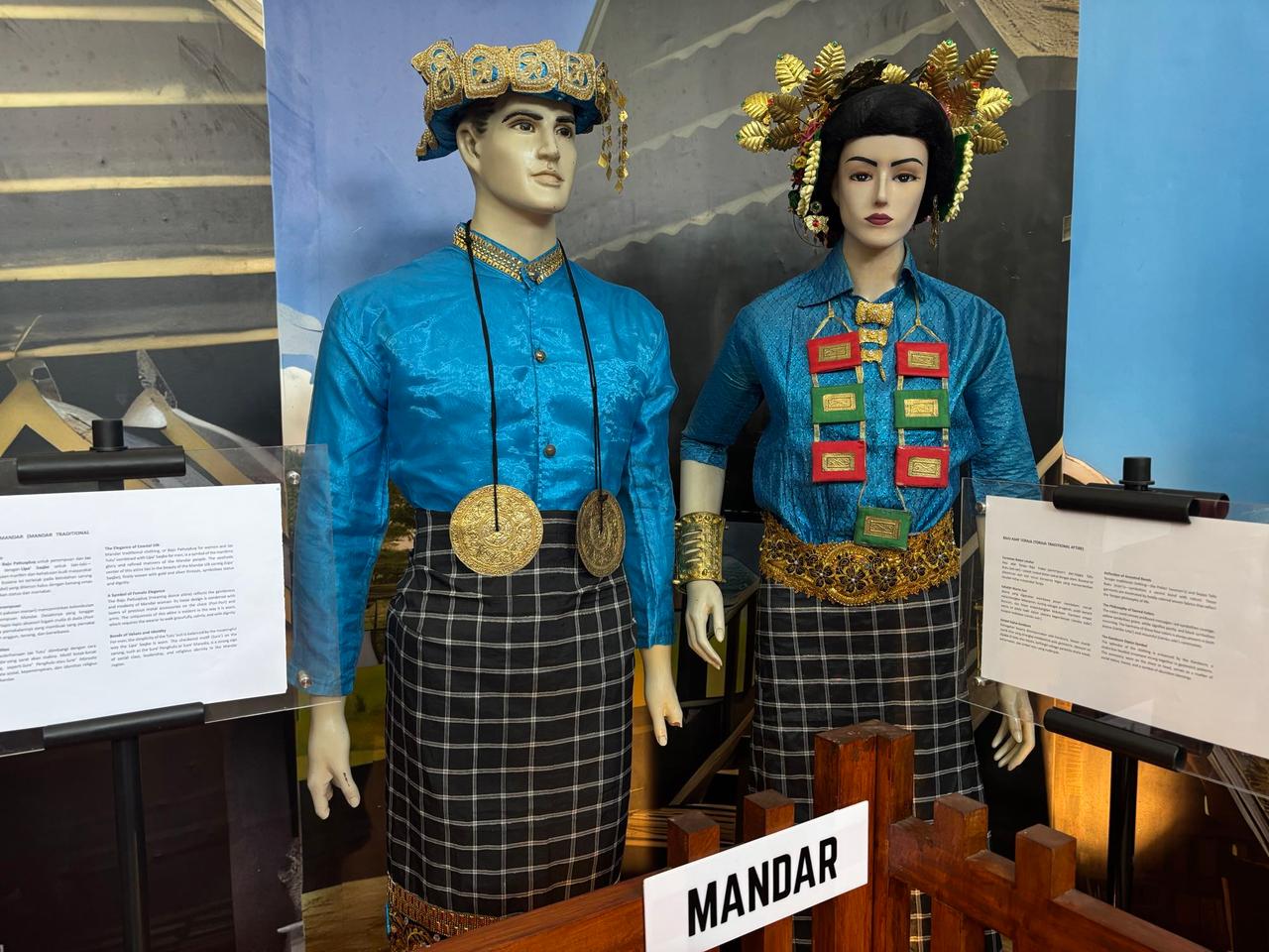 Manekin-manekin mengenakan busana pernikahan tradisional Mandar dengan hiasan kepala emas