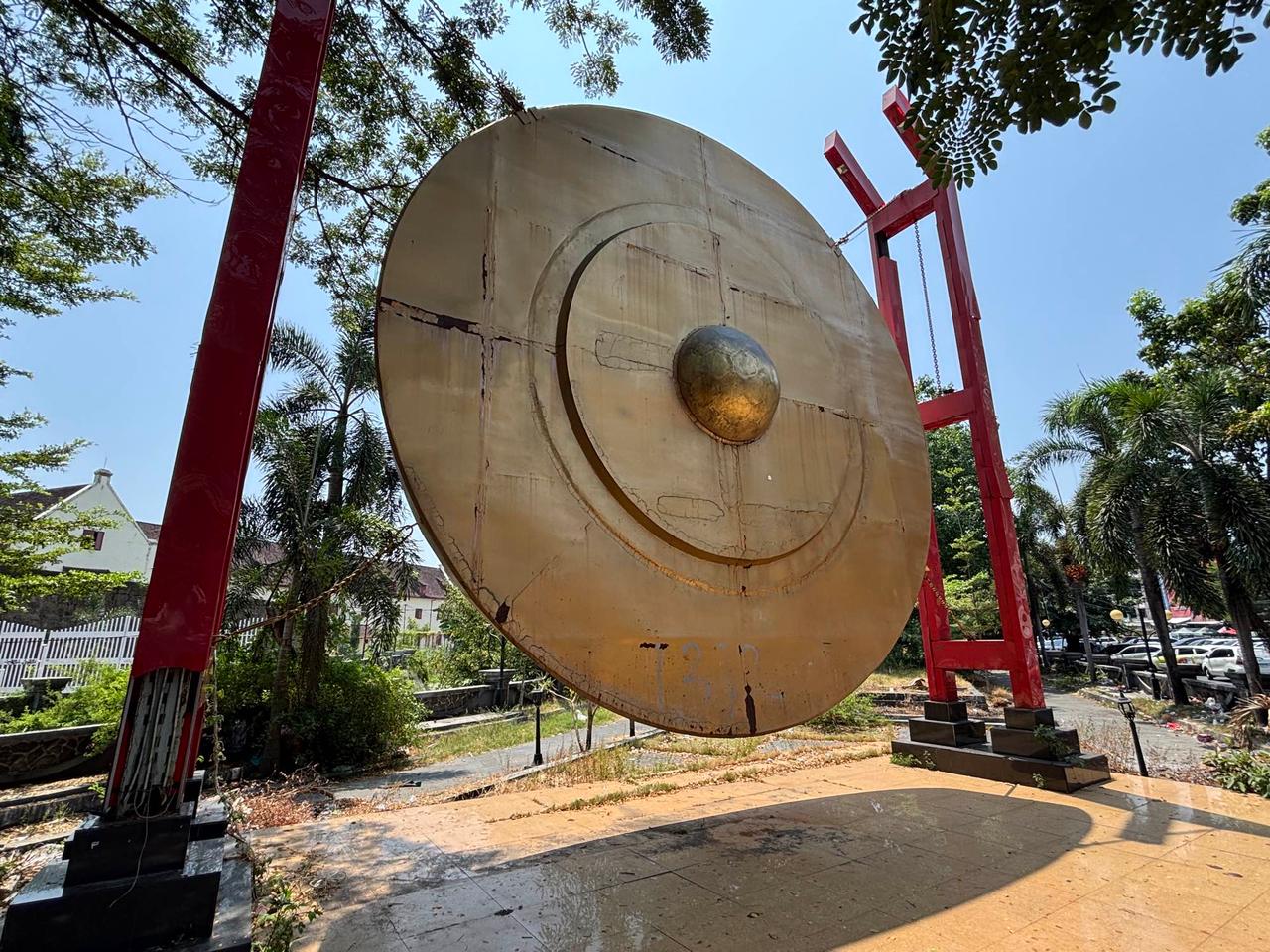 Sebuah monumen gong seremonial besar yang dipasang di atas penyangga kayu merah di Fort Rotterdam