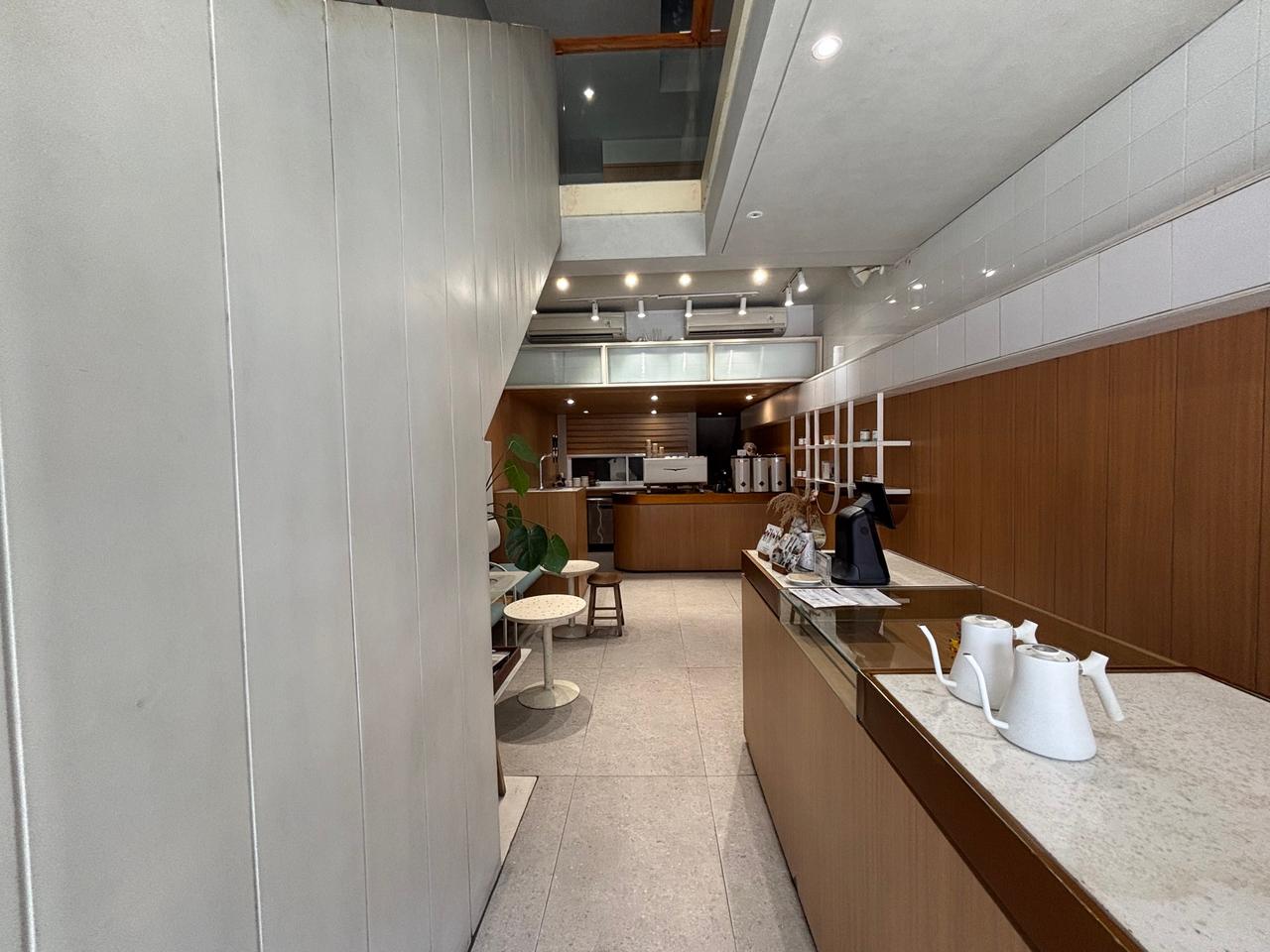 Interior berpanel kayu yang tenang dari sebuah kafe lokal modern di Makassar