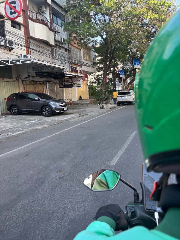 The view from the back of a Grab motorbike taxi, weaving through Makassar traffic