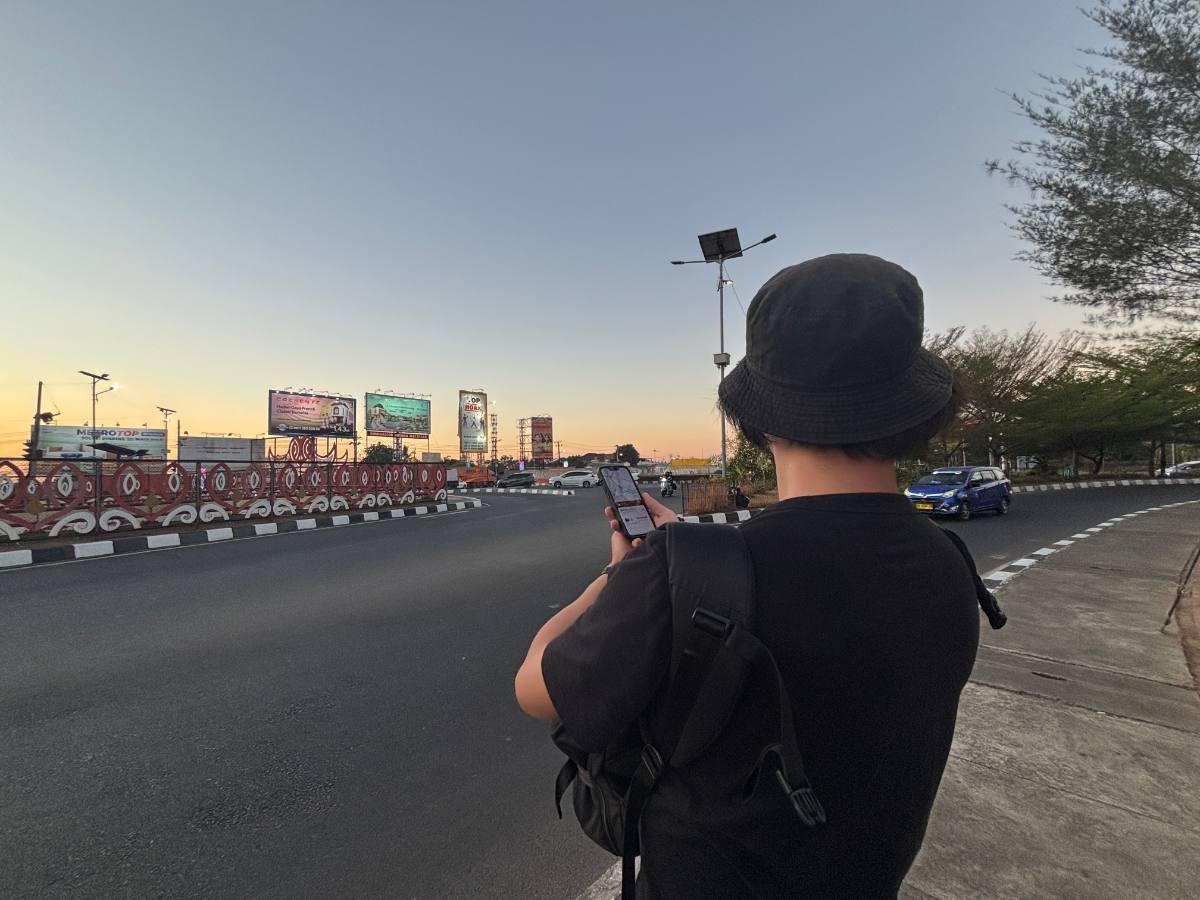 Waiting outside the airport at dusk, checking the Grab app while my friend's flight lands