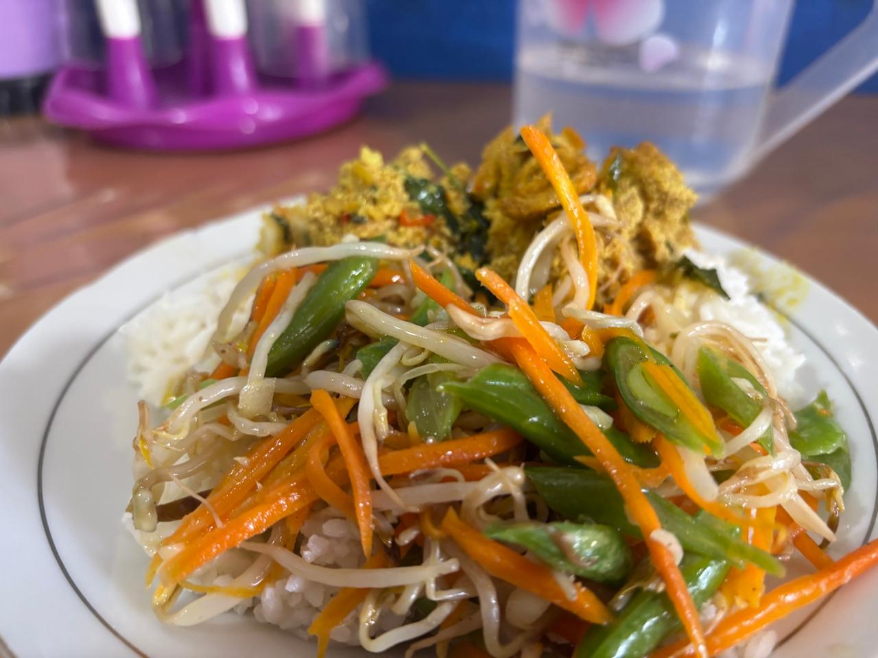 Sepiring sarapan pedas berisi nasi, sayur, dan sambal menyerupai telur ikan