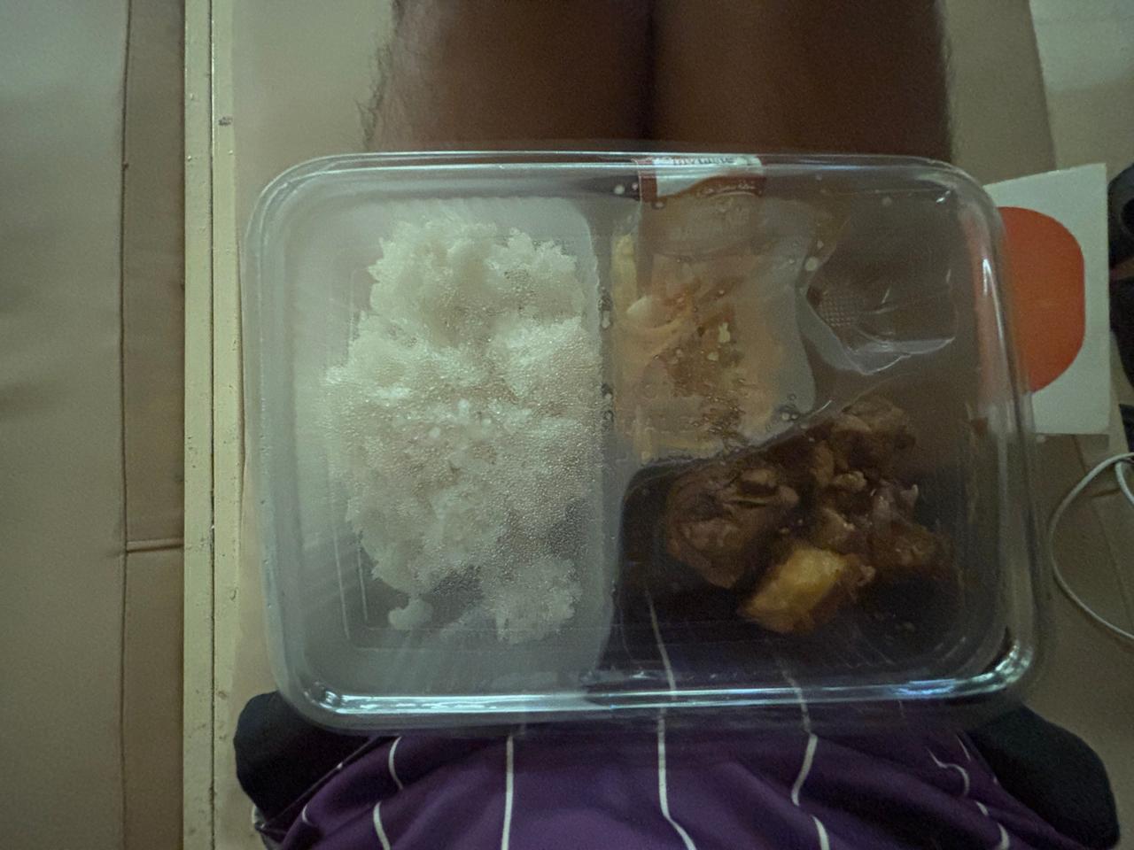 Kotak makan yang ternyata enak berisi nasi, sayur, dan daging yang dibagikan di kapal