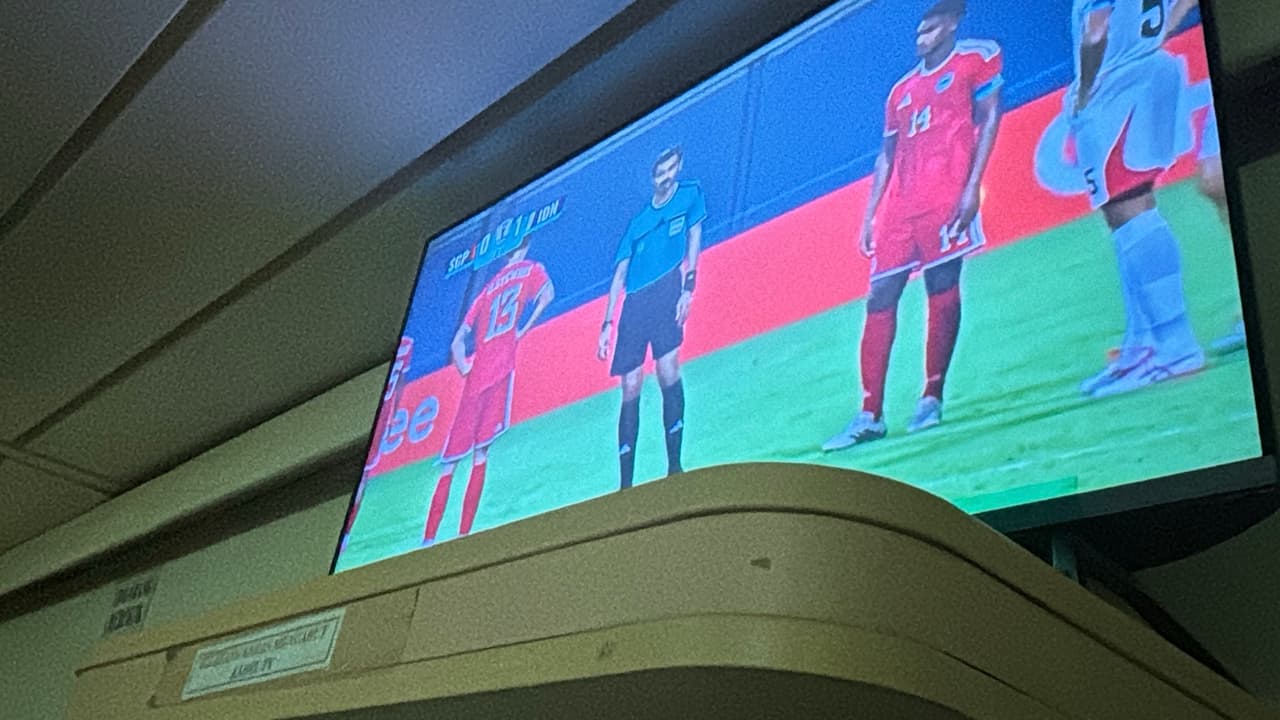Penumpang berkerumun di depan TV menonton pertandingan sepak bola di kapal Pelni